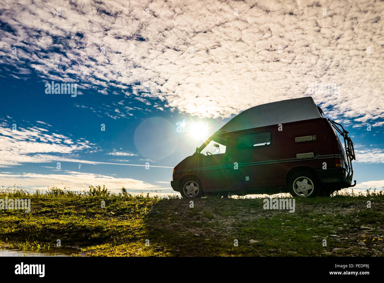 Estonie - Août 2018 : VW Transporter T4 sur mer baltique avec coucher du soleil en arrière-plan et ciel bleu avec des nuages. La Volkswagen Transporter (T4) est un van pr Banque D'Images