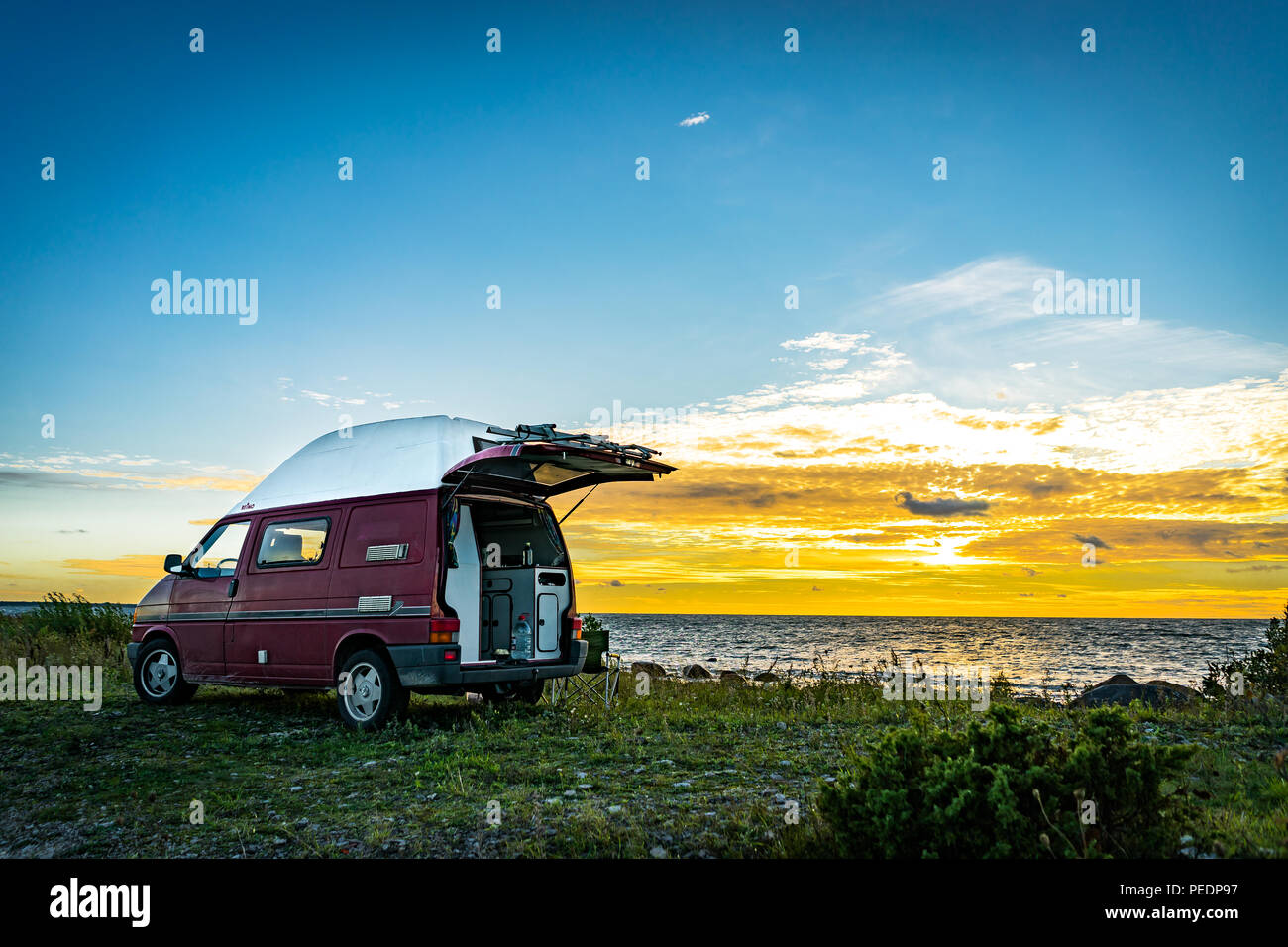 Estonie - Août 2018 : VW Transporter T4 sur mer baltique avec coucher du soleil en arrière-plan et ciel bleu avec des nuages. La Volkswagen Transporter (T4) est un van pr Banque D'Images