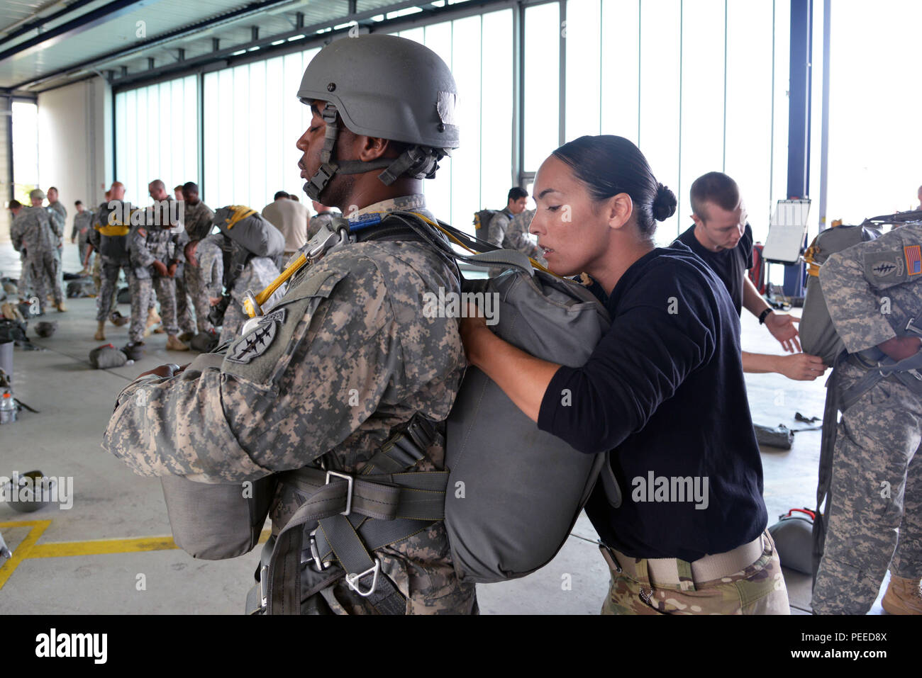 Un soldat américain affecté à l'United States Special Operations Command attend patiemment que son maître n'Jump un contrôle final sur son équipement pendant un cours de qualification de saut s'est tenue à Stuttgart Army Airfield à Stuttgart, Allemagne, le 5 août, 2015. (U.S. Photo de l'armée par Visual Spécialiste de l'information, Adam Sanders/libérés) Banque D'Images