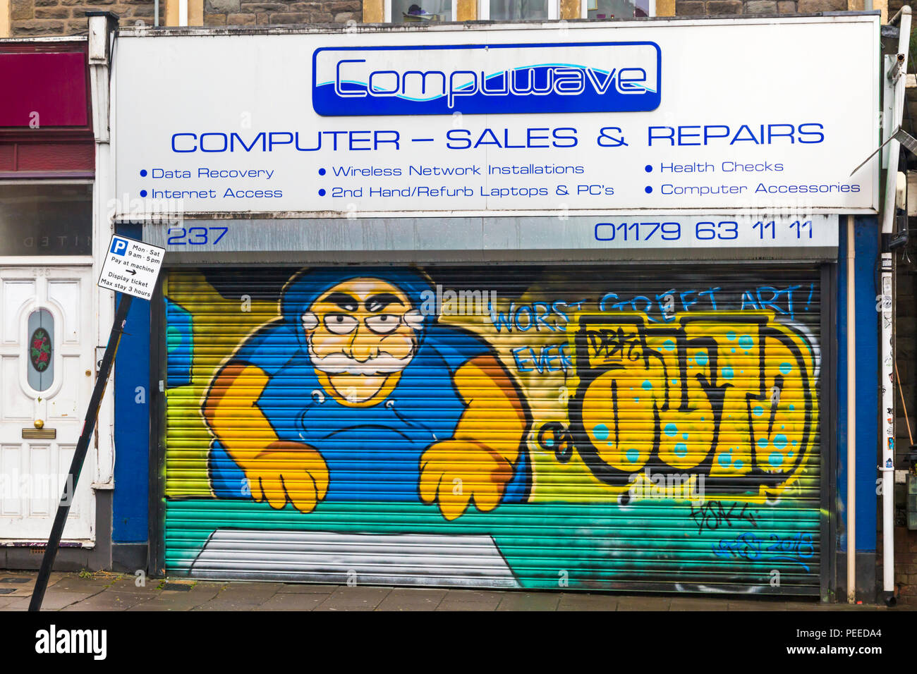 Street art sur volets de Compuwave shop à North Street, BRISTOL Southville, sur un jour de pluie en août Banque D'Images