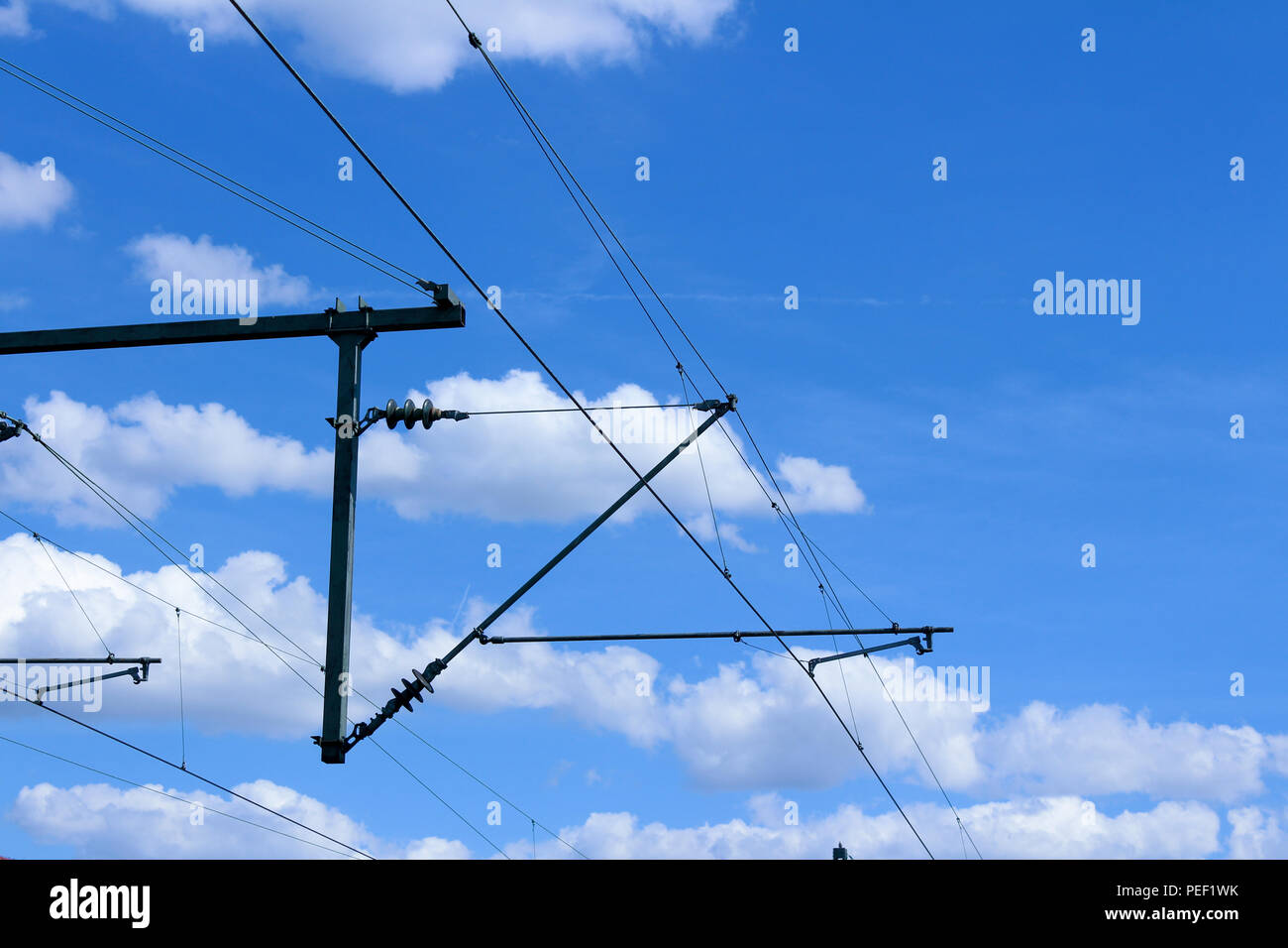 Les lignes de trains électriques électrification ferroviaire système aérien avec des câbles et ciel bleu au-dessus Banque D'Images