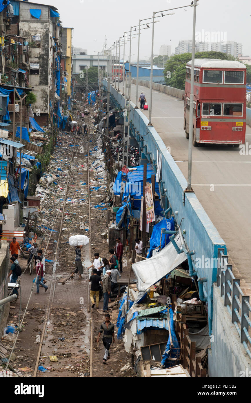 Station de bus à impériale sur route à côté de la voie ferrée couvert de déchets en plastique à Bandra, Mumbai, Inde Banque D'Images