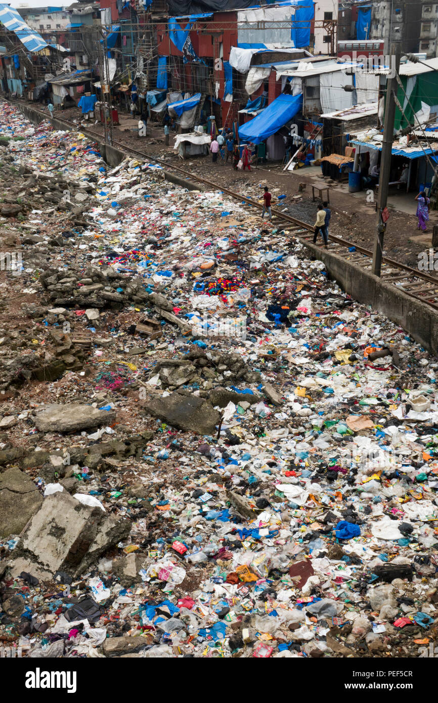 Des tas de déchets en plastique à côté de la voie ferrée et bidonville à la gare de Bandra, Mumbai, Inde Banque D'Images