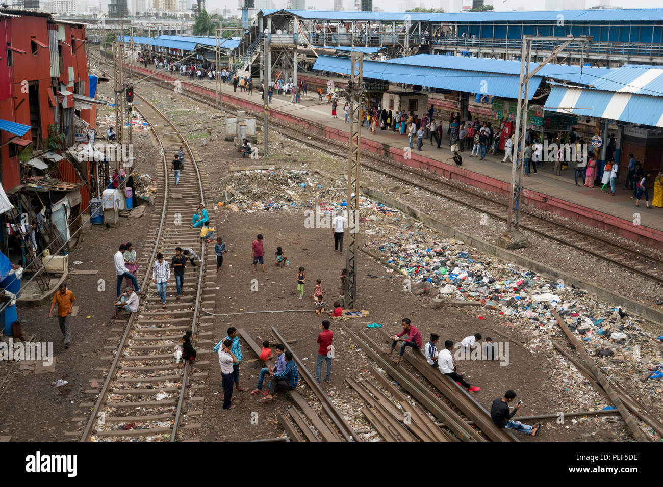 Les gens de bidonville avec des tas de détritus en plastique sur les voies près de la gare de Bandra, Mumbai, Népal Banque D'Images