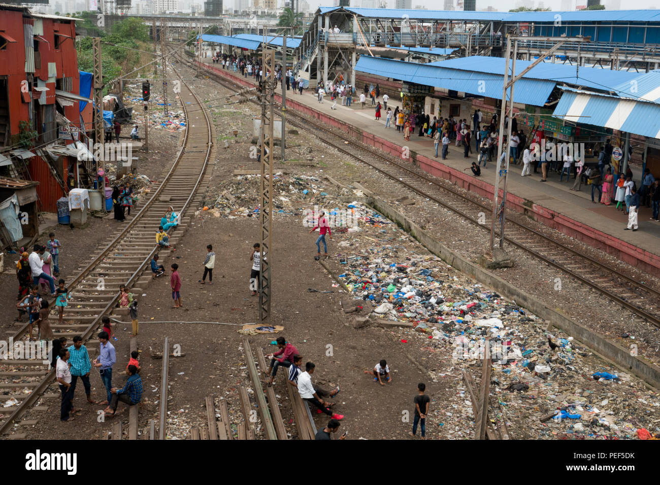 Les gens de bidonville avec des tas de détritus en plastique sur les voies près de la gare de Bandra, Mumbai, Népal Banque D'Images