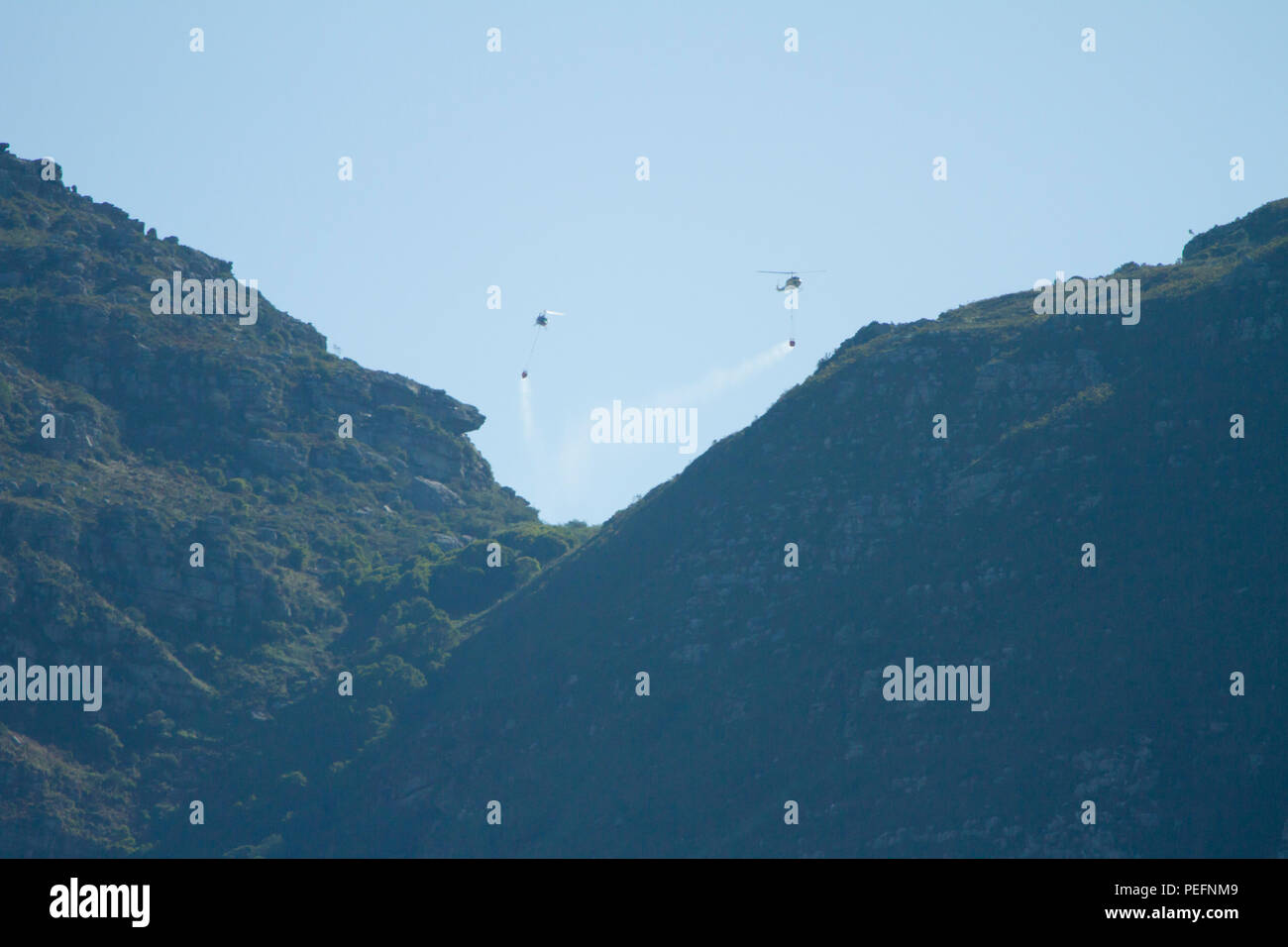 Pompiers lutter contre un incendie de forêt sur la montagne de la table en utilisant des hélicoptères Banque D'Images
