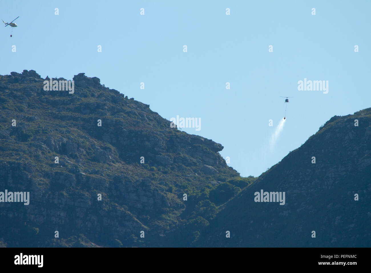 Pompiers lutter contre un incendie de forêt sur la montagne de la table en utilisant des hélicoptères Banque D'Images