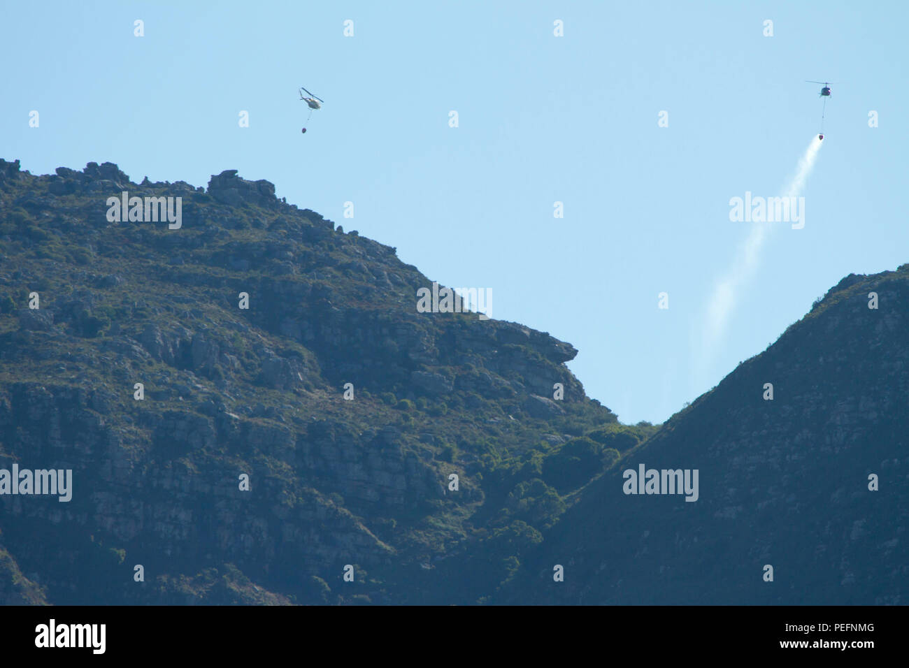 Pompiers lutter contre un incendie de forêt sur la montagne de la table en utilisant des hélicoptères Banque D'Images