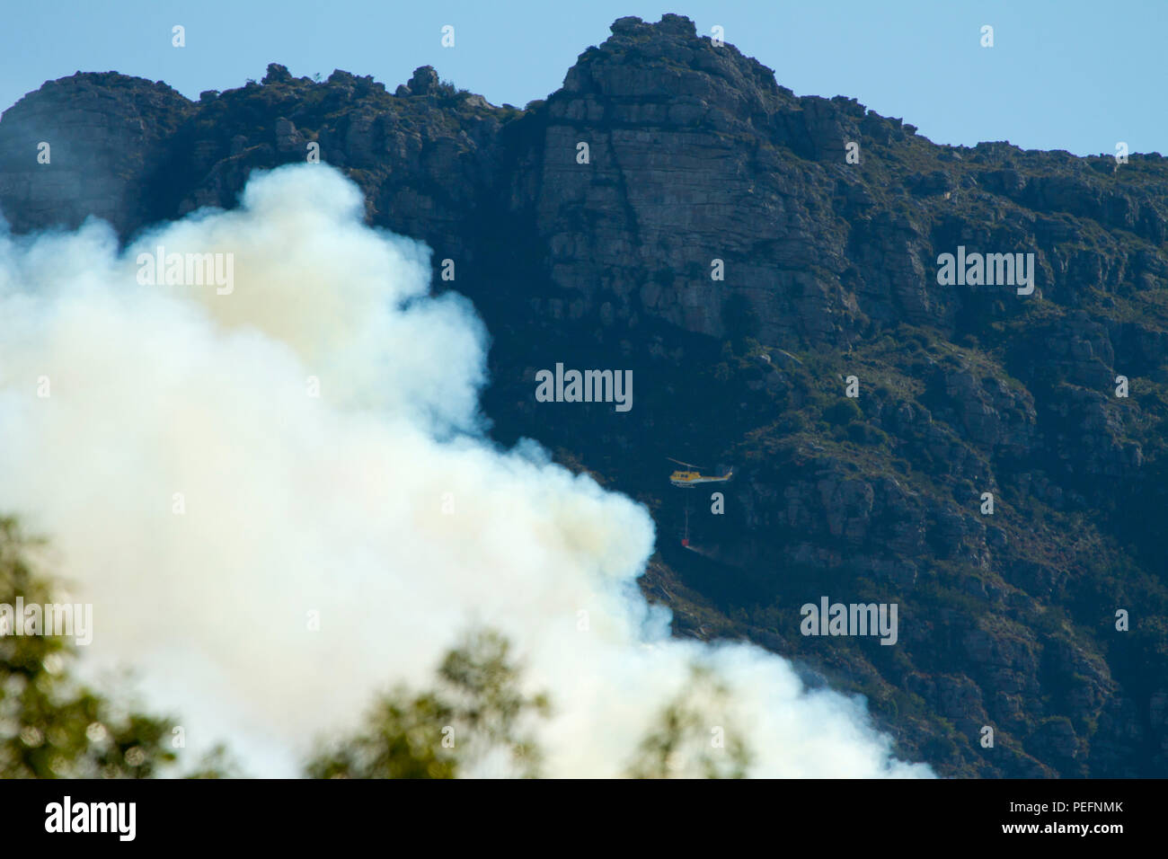 Pompiers lutter contre un incendie de forêt sur la montagne de la table en utilisant des hélicoptères Banque D'Images