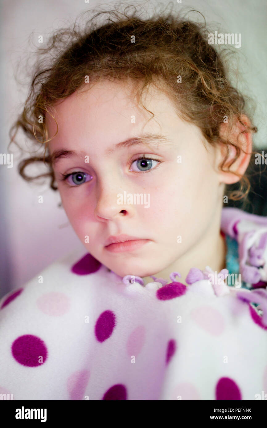 Portrait d'un curly haired fillette de six ans en pleine réflexion Banque D'Images