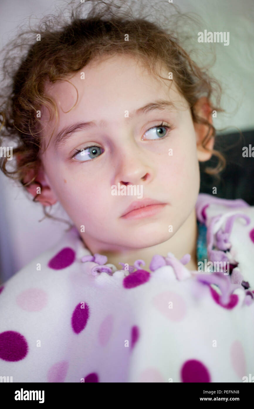 Portrait d'un curly haired fillette de six ans en pleine réflexion Banque D'Images