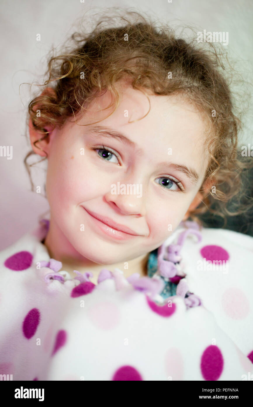 Portrait d'un curly haired fillette de six ans en pleine réflexion Banque D'Images