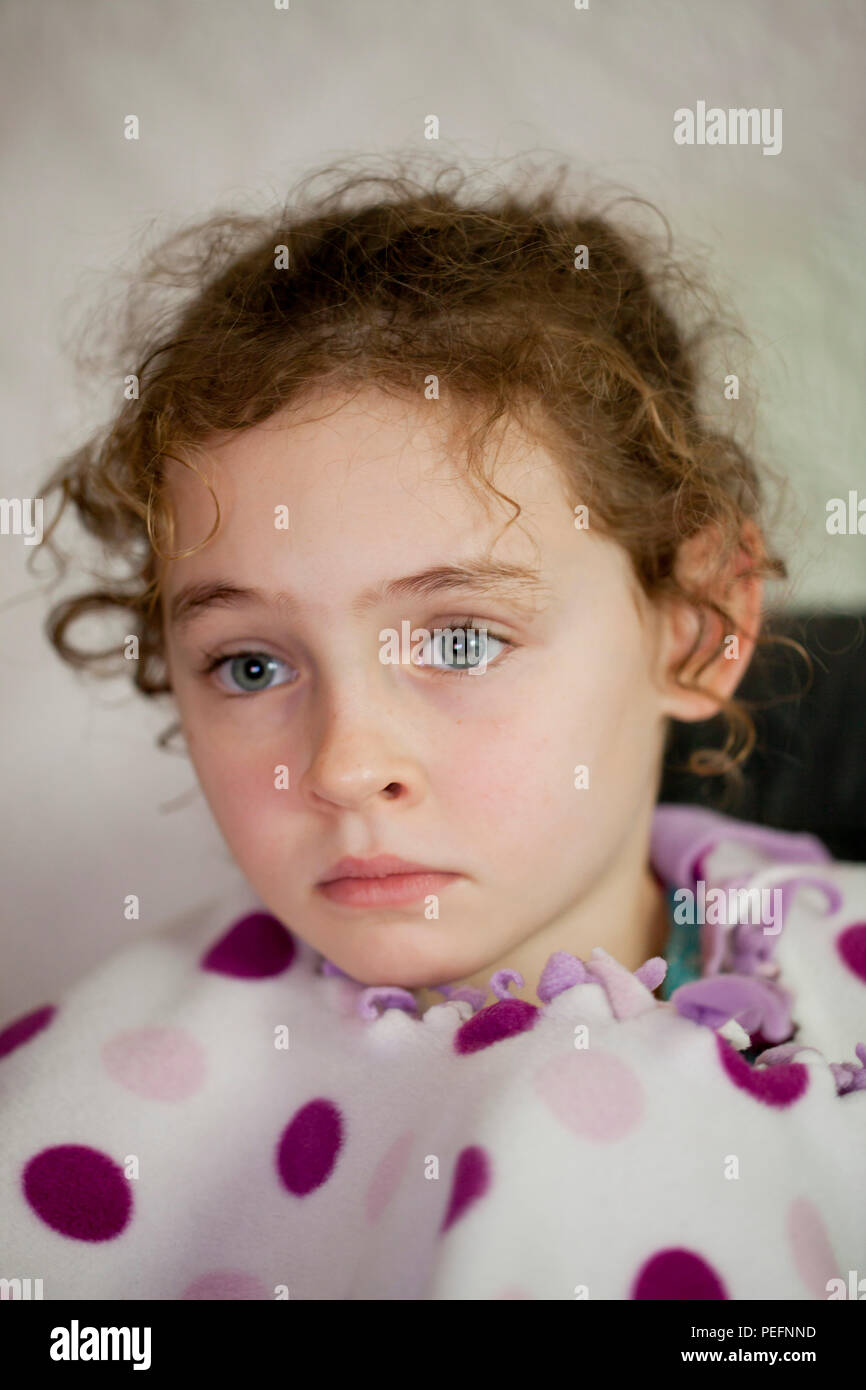 Portrait d'un curly haired fillette de six ans en pleine réflexion Banque D'Images