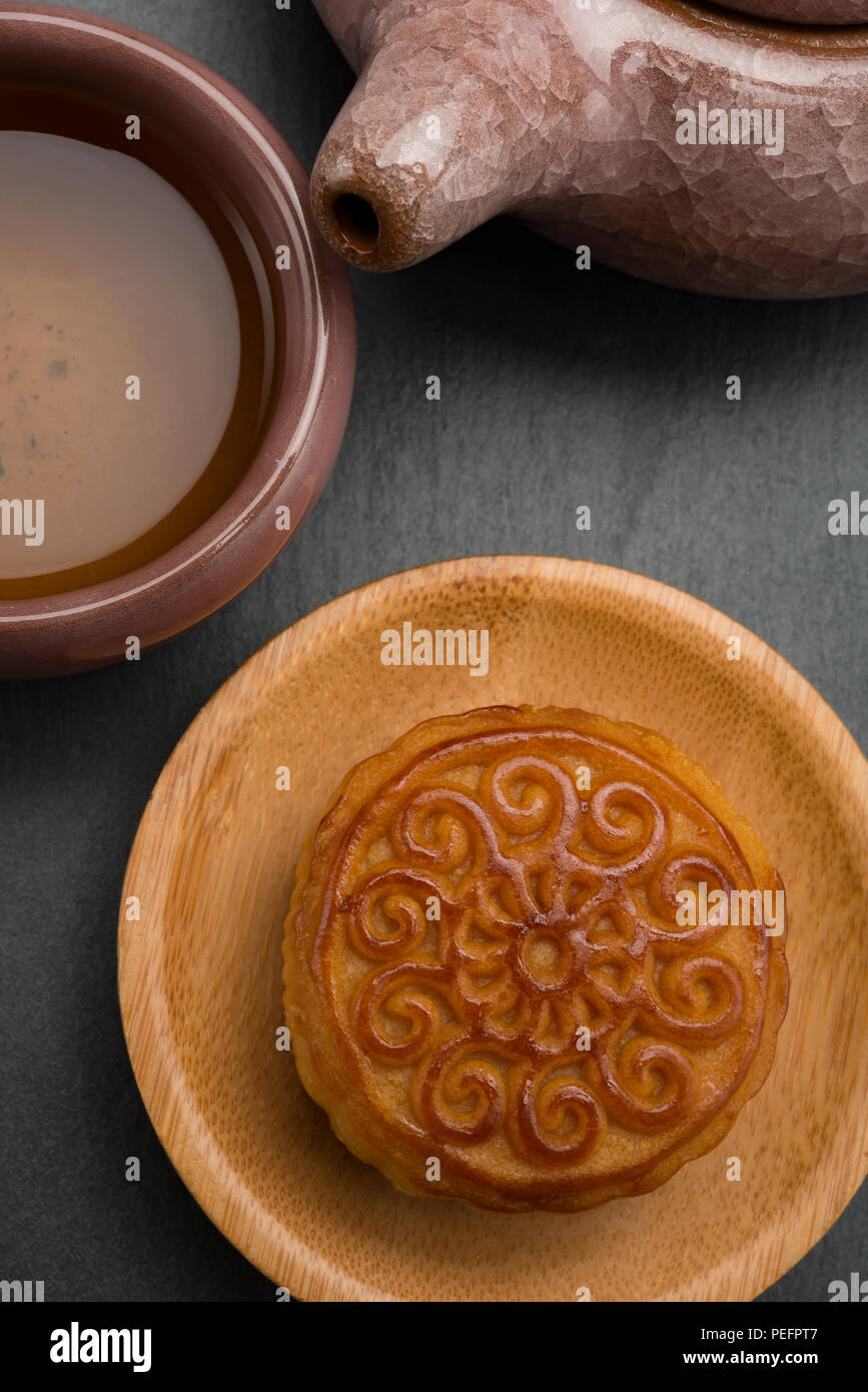 Top View Studio shoot de mooncake traditionnel chinois avec thé et théière sur fond noir composition verticale Banque D'Images