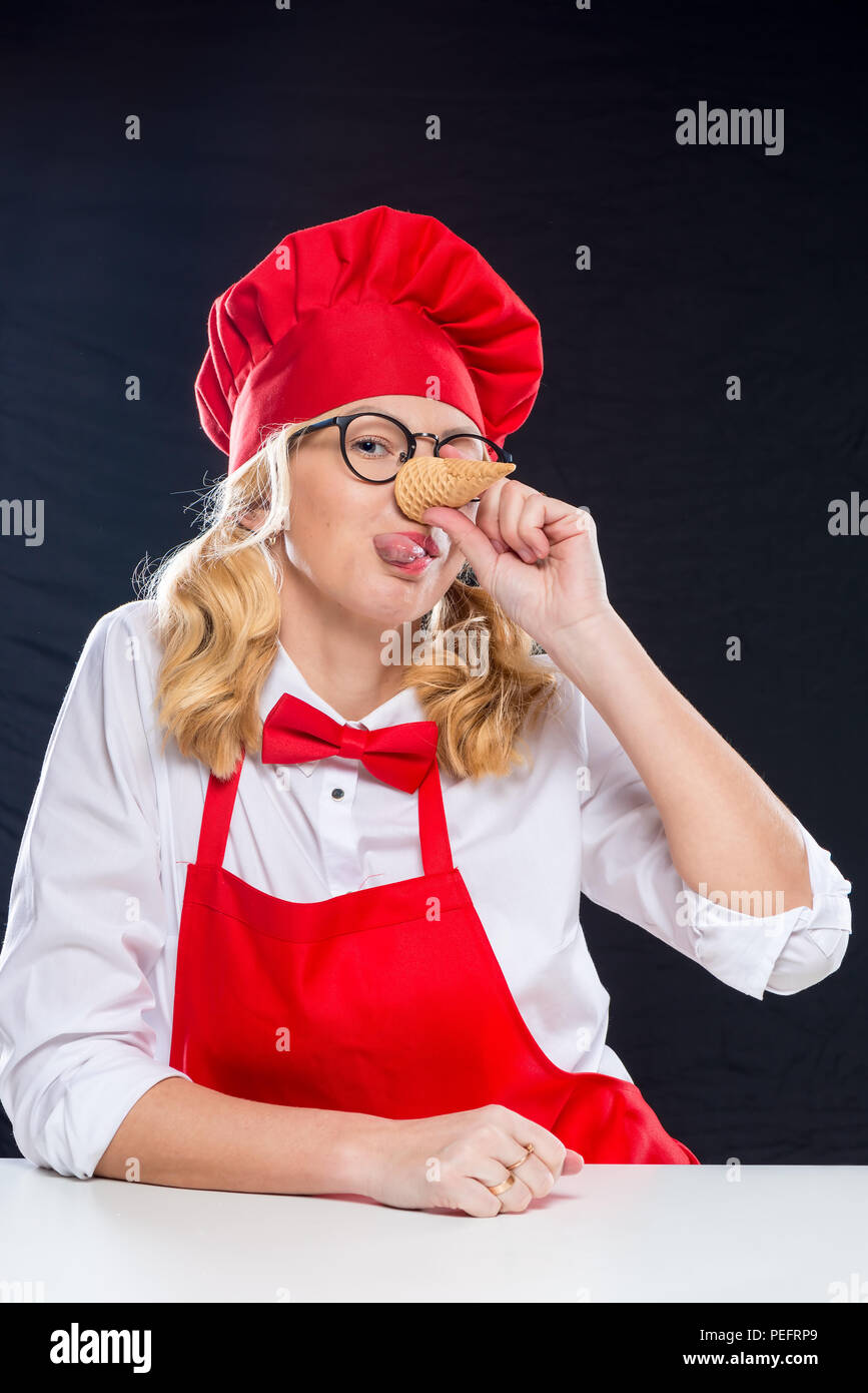 Animateur avec coupe femme gaufre à la crème glacée grimaces sur fond noir Banque D'Images