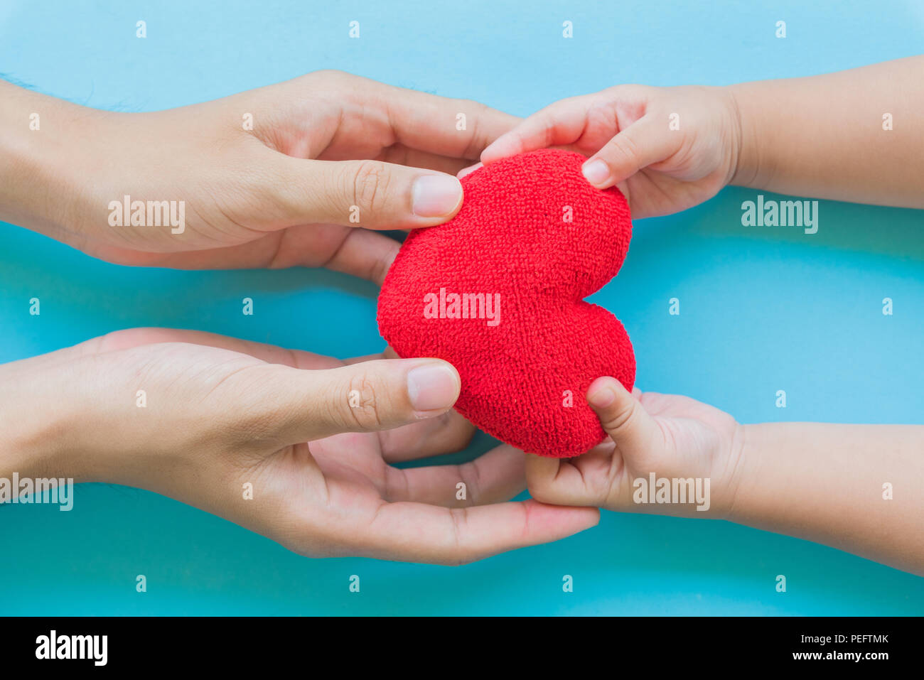 La main de l'enfant coeur rouge à son père, heureux les relations familiales, la Saint-Valentin, la Fête des pères, l'amour et les soins de concept. Banque D'Images