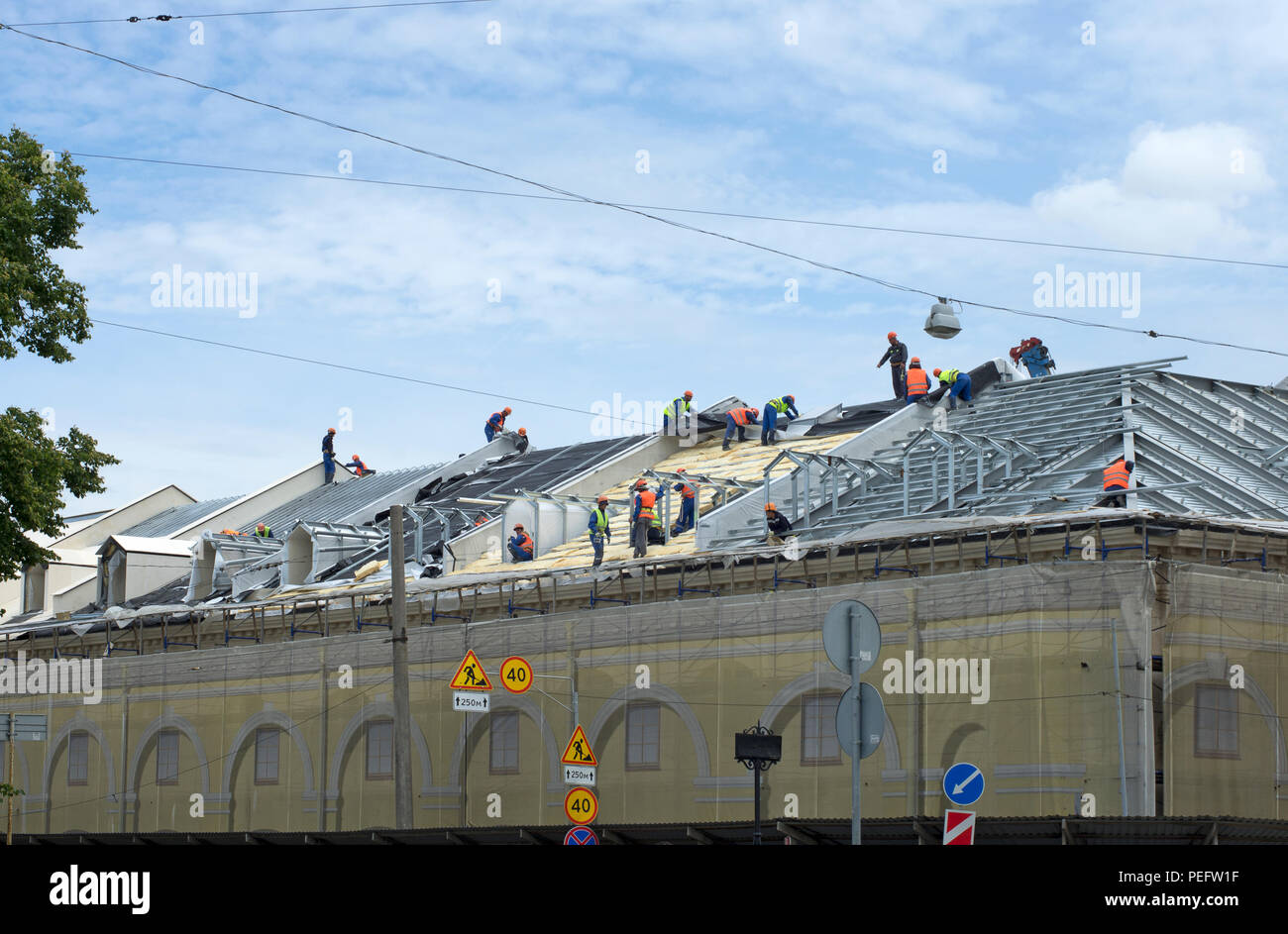 Les constructeurs de l'équipe n'installation d'un toit de l'immeuble à l'été sous un ciel bleu Banque D'Images