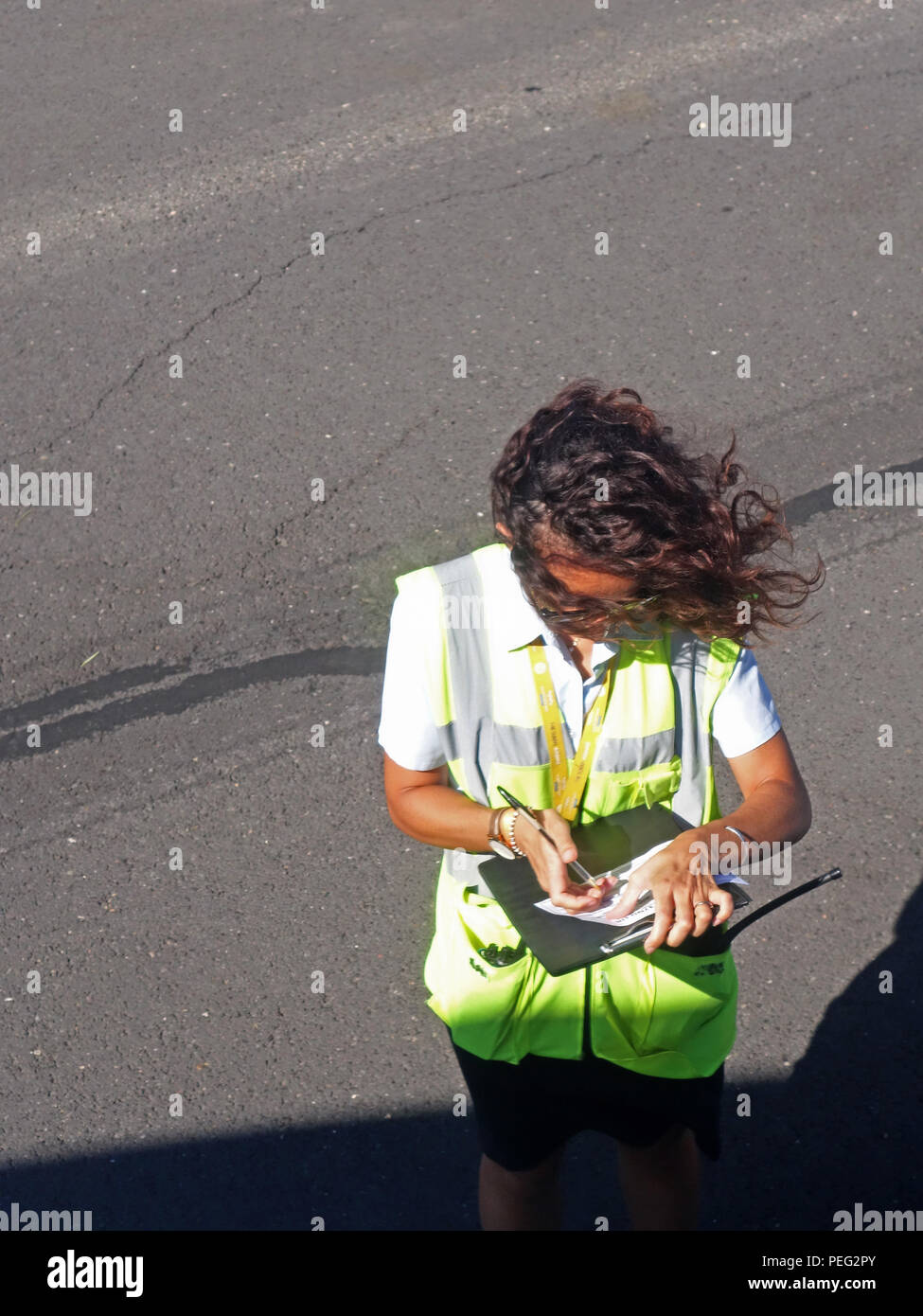 Dame balayées par le personnel des compagnies aériennes plan écrit en se tenant sur le rapport détaillé de l'aéroport à côté de l'aire d'un avion de Ryanair dans l'aéroport de Béziers Banque D'Images