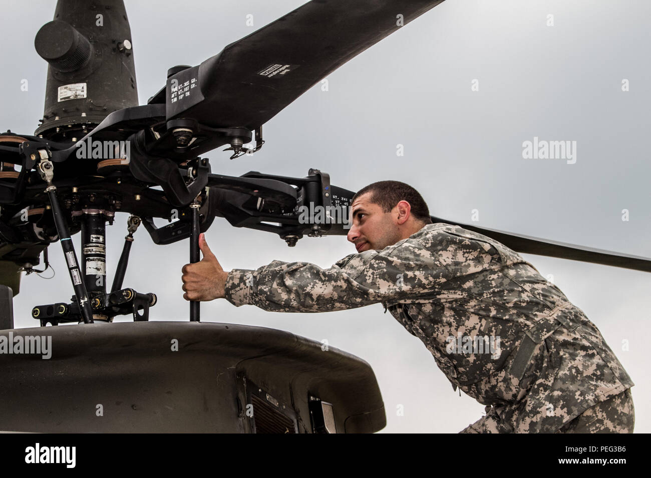 La CPS. Daniel Gomez, un OH-58 Kiowa mécanicien du 2e Escadron, 6e régiment de cavalerie, 2e Brigade d'aviation de combat, travailler jour et nuit au Complexe de tir réel Rodriguez, la Corée du Sud. Banque D'Images