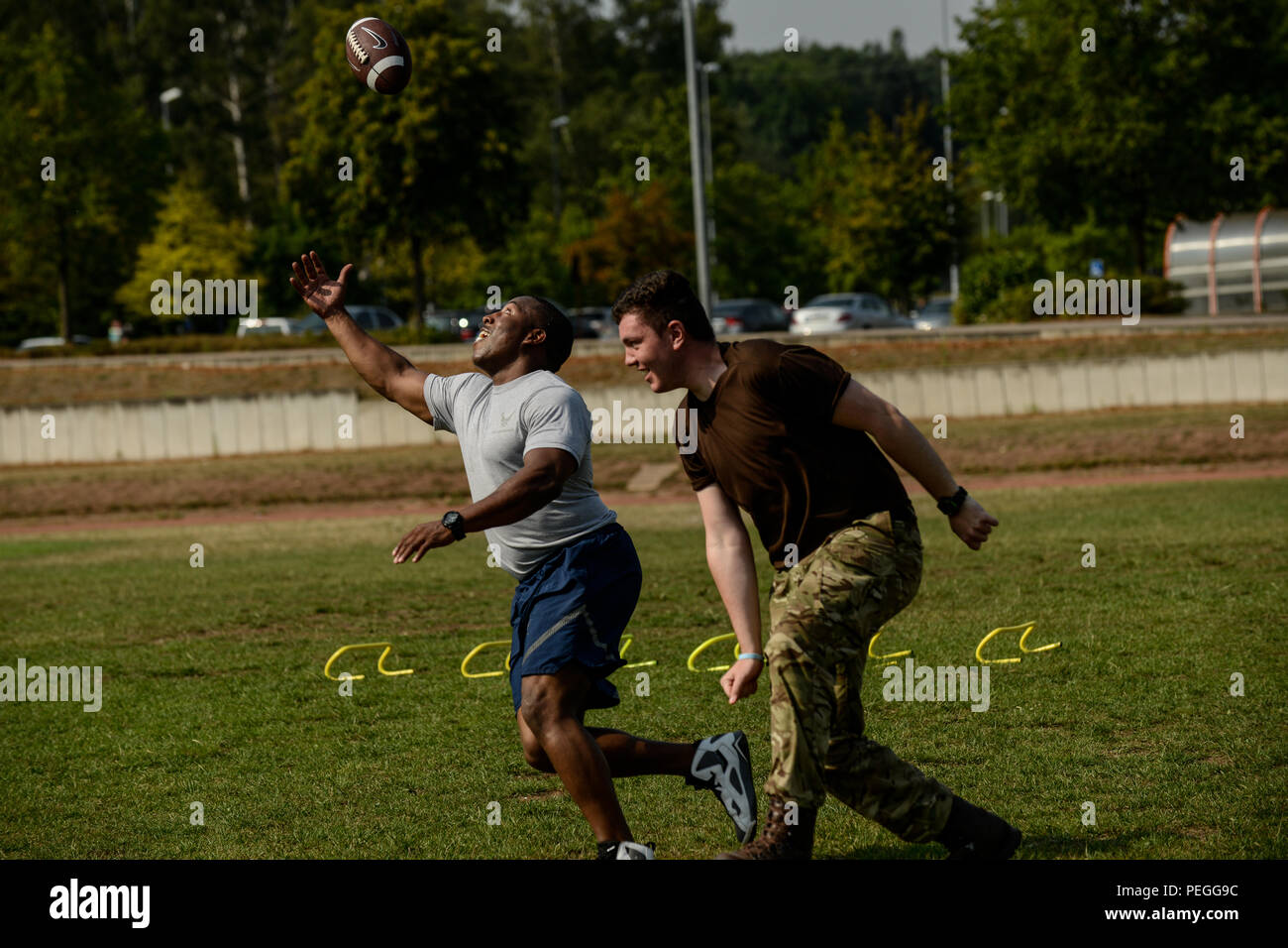 Le s.. Darryl Brown, 786 e Escadron de génie civil sous-officerin chargé de contrôle du véhicule et d'un Royal Air Force Formation des cadets de l'Air Corps, jouer au football pendant une course d'obstacles 10 Août, 2015, le Vogelweh, Allemagne. Les cadets a effectué quatre séries de lancers de pneus, exercices de football, un travail de vitesse et sprints durant le cours organisé par l'Académie des sous-officiers Kisling. (U.S. Air Force photo/Senior Airman Nicole Sikorski Banque D'Images