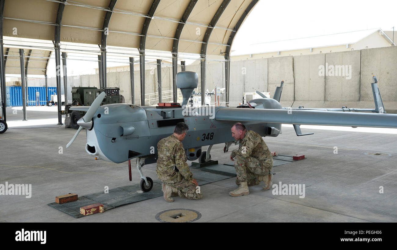 L'AÉRODROME DE KANDAHAR, en Afghanistan (16 août 2000 6, 2015) La Marine américaine Le Lieutenant Cmdr. John Bercey, gauche, officier responsable, Groupe de travail Copperhead véhicule aérien sans pilote tactique, Détachement et le Capf. Timothée Wood, directeur de théâtre, TF Copperhead, inspecter un MQ-5B Hunter à l'aérodrome de Kandahar. Bercey et le bois servent de renforts individuels et utiliser le MQ-5B associée à l'UAV Copperhead système à détecter les engins explosifs avec grand succès en Afghanistan sur la mission de l'OTAN soutien résolu. (U.S. Photo de la marine par le lieutenant Kristine Volk/libérés) Banque D'Images