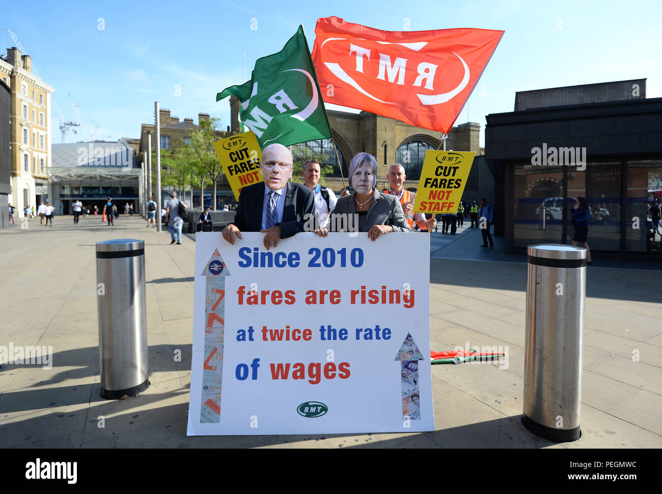 Les membres de l'industrie ferroviaire, maritime et Transport union (RMT) habillé comme premier ministre Theresa Mai et secrétaire aux Transports Chris Grayling prendre part à une manifestation sur le voyage en train à l'extérieur de la gare de King's Cross à Londres. Banque D'Images