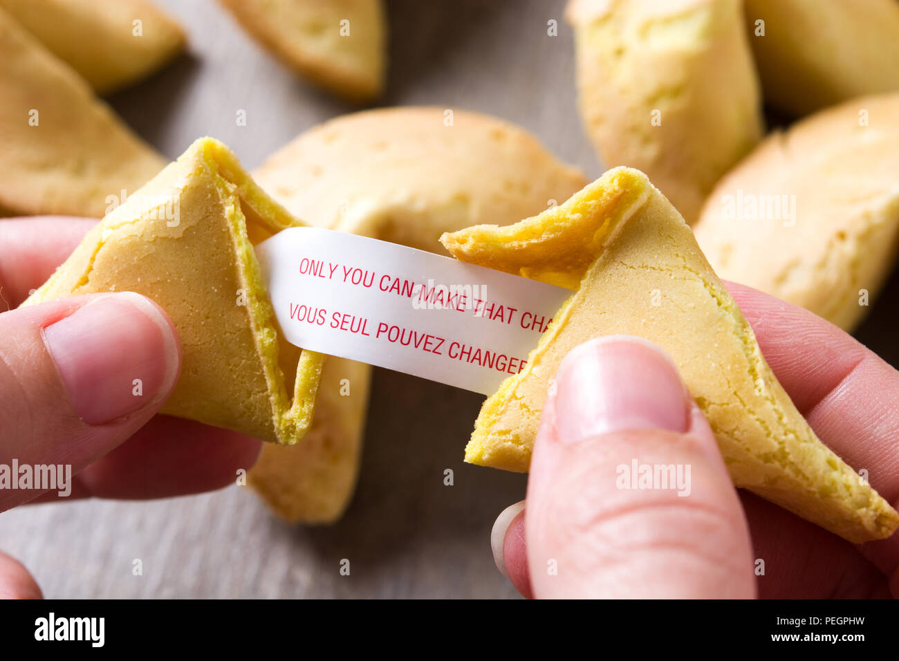 Ouverture main biscuit de fortune avec le message sur le papier sur la table en bois Banque D'Images