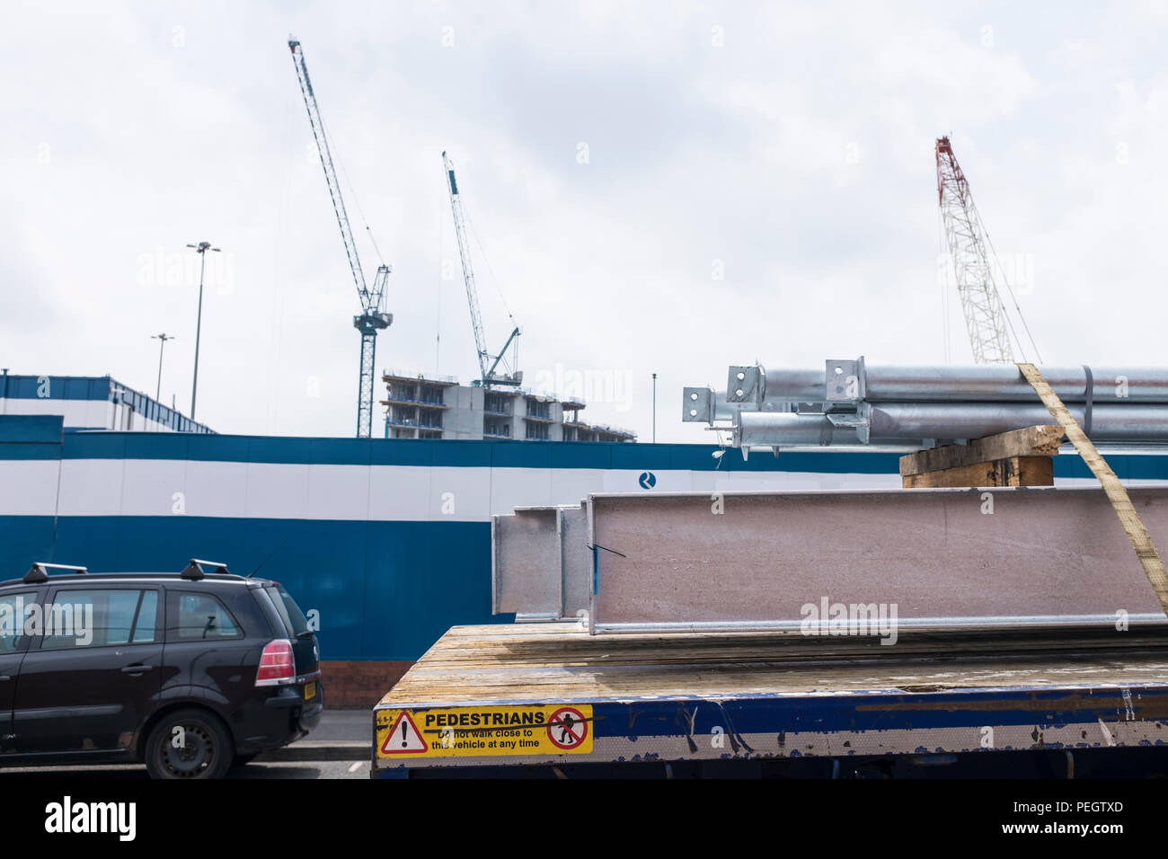 Les poutres en acier à l'arrière du camion avec grue à l'arrière-plan Banque D'Images