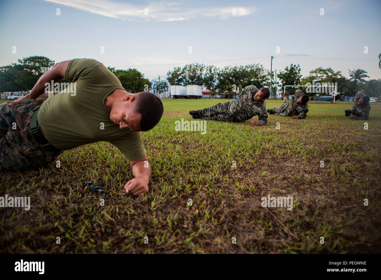 Le Corps des Marines des États-Unis. Nelson Ortiz, un membre de l'équipe avec la coopération de sécurité maritime à des fins spéciales, Team-Honduras Les Force-Southern participe au groupe de commande exercices d'échauffement lors d'une session d'entraînement physique avec les marines de la base navale du Honduras à Puerto Castilla, le Honduras, le 17 août, 2015. SCT-Honduras est actuellement déployé dans le cadre de l'SPMAGTF-SC pour aider le Centro de Adiestramiento avec Naval la mise en œuvre d'un curriculum de formation pour créer un programme marin du Honduras. (U.S. Marine Corps Photo par le Cpl. Katelyn Hunter/relâché). Banque D'Images