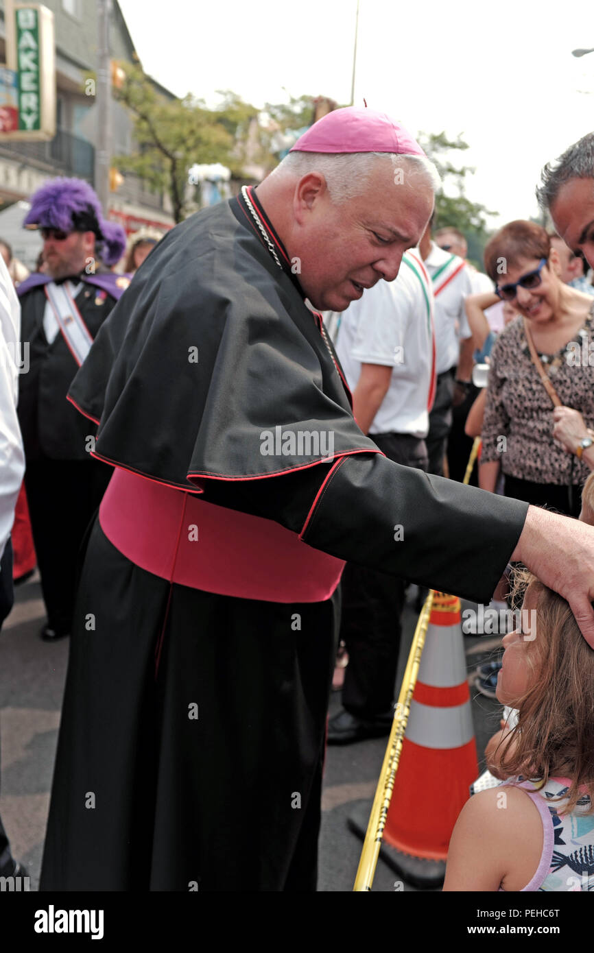 Cleveland, Ohio, États-Unis. 15 août 2018. L'évêque de Cleveland Nelson Perez bénit un enfant debout sur le côté de la route en observant la fête de 2018 de la procession d'Assomption dans La Petite Italie de Cleveland. La fête de célébration est une fusion de culture et de foi. Crédit: Mark Kanning/Alay Live News Banque D'Images