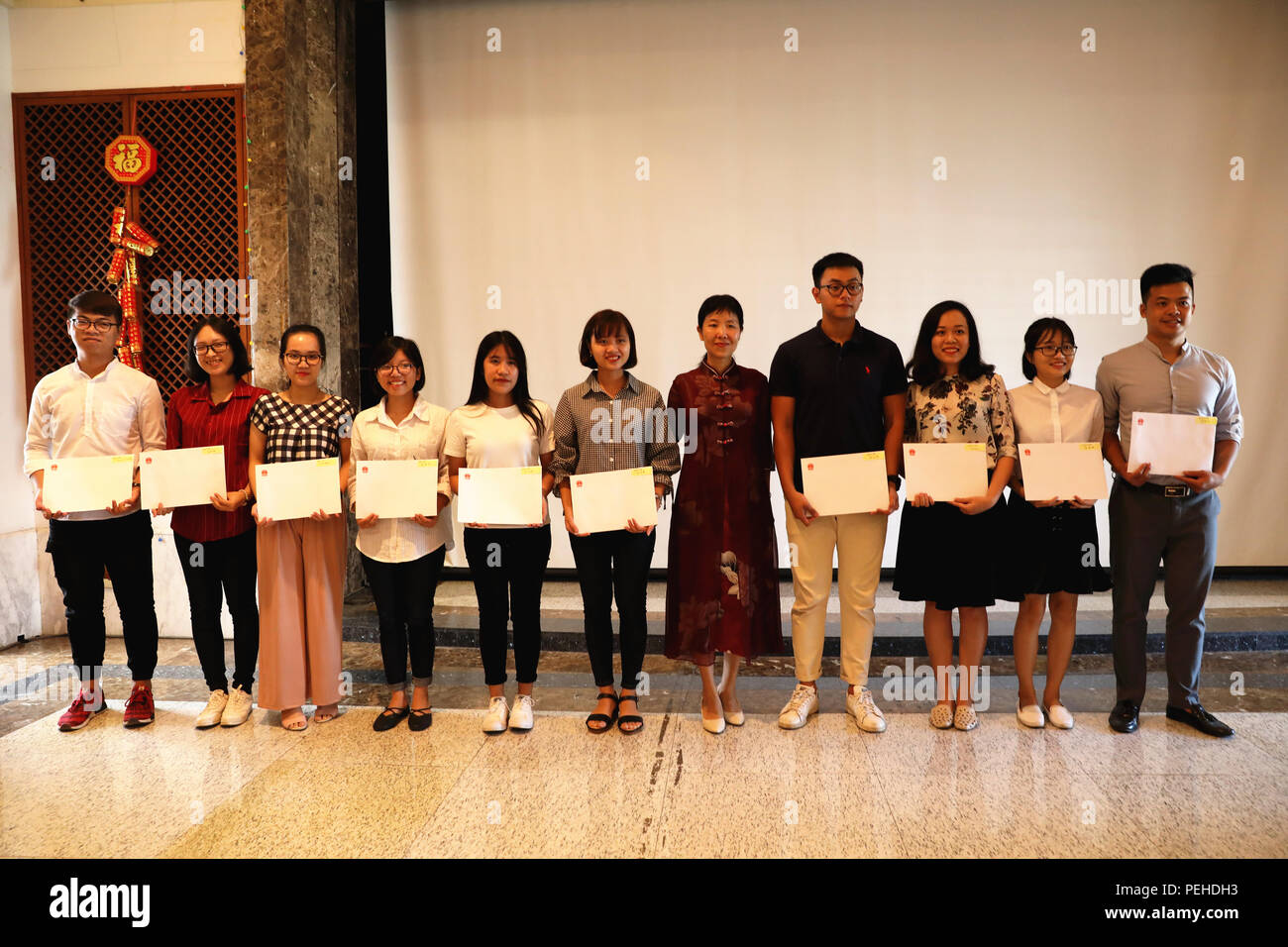 Hanoi, Vietnam. Août 13, 2018. Chargé d'affaires de l'ambassade de Chine au Vietnam Yin Haihong (5e R) pose pour des photos avec le Gouvernement chinois 2018 gagnants des bourses à Hanoi, Vietnam, 13 août 2018. L'ambassade de Chine au Vietnam le lundi a tenu une cérémonie de remise des bourses du gouvernement chinois de 104 Vietnamiens. Credit : Wang Di/Xinhua/Alamy Live News Banque D'Images