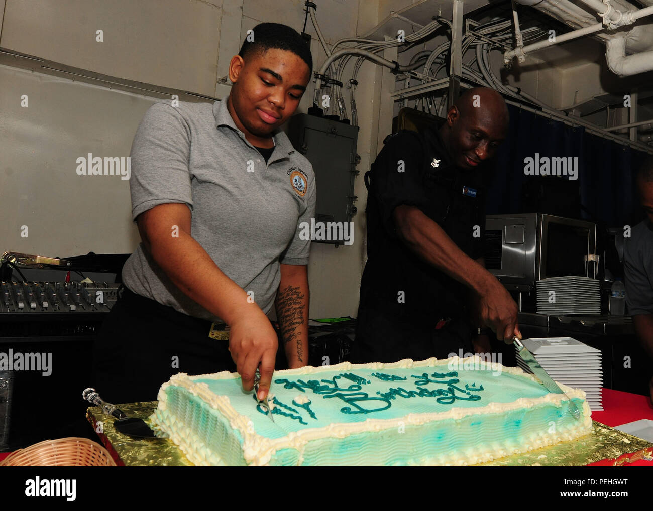 150820-N-PG340-108 Golfe Arabique (20 août 2015) - Spécialiste culinaire Seaman Apprentice Jazmine Scott, de Pittsburgh (à gauche), et chef de l'Aviation (sélectionner) Maître de Manœuvre (carburant) Leslie Hammond, de Brooklyn, N.Y. (droite), couper le gâteau au cours de la célébration de l'anniversaire d'août sur les ponts de mess à bord du porte-avions USS Theodore Roosevelt (CVN 71). Theodore Roosevelt est déployée dans la zone 5e flotte américaine d'appui à l'opération d'opérations inhérentes à résoudre, dans l'Iraq et la Syrie comme dirigé, les opérations de sécurité maritime et les efforts de coopération en matière de sécurité dans le théâtre dans le reg Banque D'Images