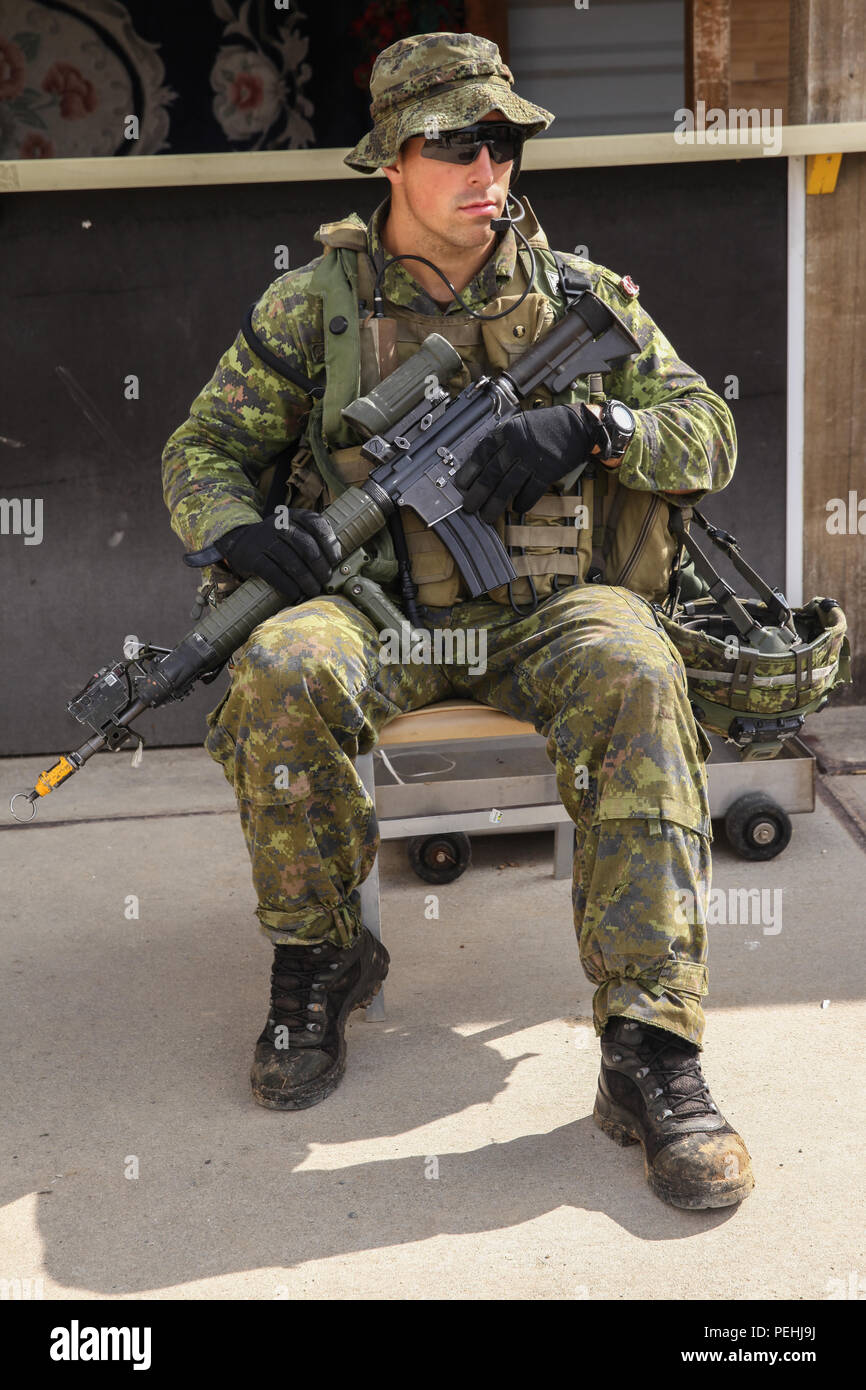 Un soldat canadien, 3e Bataillon, Royal 22e Régiment à l'écoute de sa direction à la radio tout en menant, par conséquent, ils réagissent au contact pendant l'exercice Allied Spirit II à l'armée américaine dans le centre de préparation interarmées multinationale Hohenfels, Allemagne, le 19 août 2015. Allied Spirit II est une action décisive de l'environnement de formation qui implique l'exercice de plus de 3 500 soldats américains, alliés et les pays partenaires, l'accent sur la création de partenariats et d'interopérabilité entre tous les pays participants, et soulignant le commandement de mission, l'intelligence, de soutien, et d'incendies. (U.S. Arm Banque D'Images