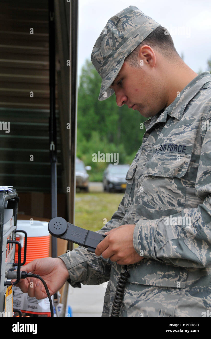 Airman Senior Justin Becker, un technicien radio avec le 176e vol de communication, permet de connecter un micro à la main sur l'équipement de transmission radio Joint Base Elmendorf-Richardson, Alaska, le 16 août 2015, au cours de l'exercice Polar Guard 15-1. Les membres du 176e Groupe de soutien de la Mission d'environ 20 différentes spécialités d'emploi former dans leurs compétences en mission de guerre durant les quatre jours de l'exercice Polar Guard 15-1. (U.S. Air National Guard photo de Tech. Le Sgt. N. Alicia Halla/libérés) Banque D'Images