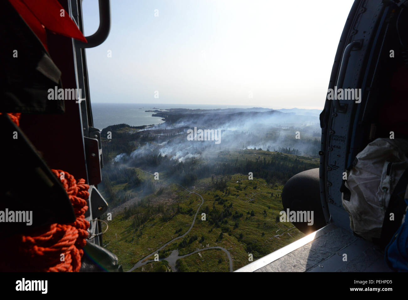 Une station d'air de la Garde côtière canadienne procède à un survol de l'équipage Kodiak Kodiak avec City Fire Department Chef Jim Mullican d'un incendie de forêt dans la région de Chiniak sur l'île Kodiak, Alaska, le 28 août 2015. Les équipages de la Garde côtière canadienne souvent aider les partenaires de l'agence avec soutien aérien pour aider les intervenants à mieux comprendre d'un incident en cours. (U.S. Photo de la Garde côtière par Maître de 1re classe Kelly Parker) Banque D'Images