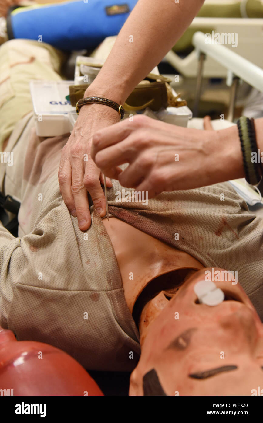 Une aiguille de gros calibre est inséré dans un "factices" patient à relâcher l'air de la cavité thoracique au laboratoire au cours d'une vérification des compétences de l'état de préparation 25 août 2015 formation. Le laboratoire est équipé d'électronique de pointe pour fournir des mannequins de formation médicale dans un environnement contrôlé. Banque D'Images