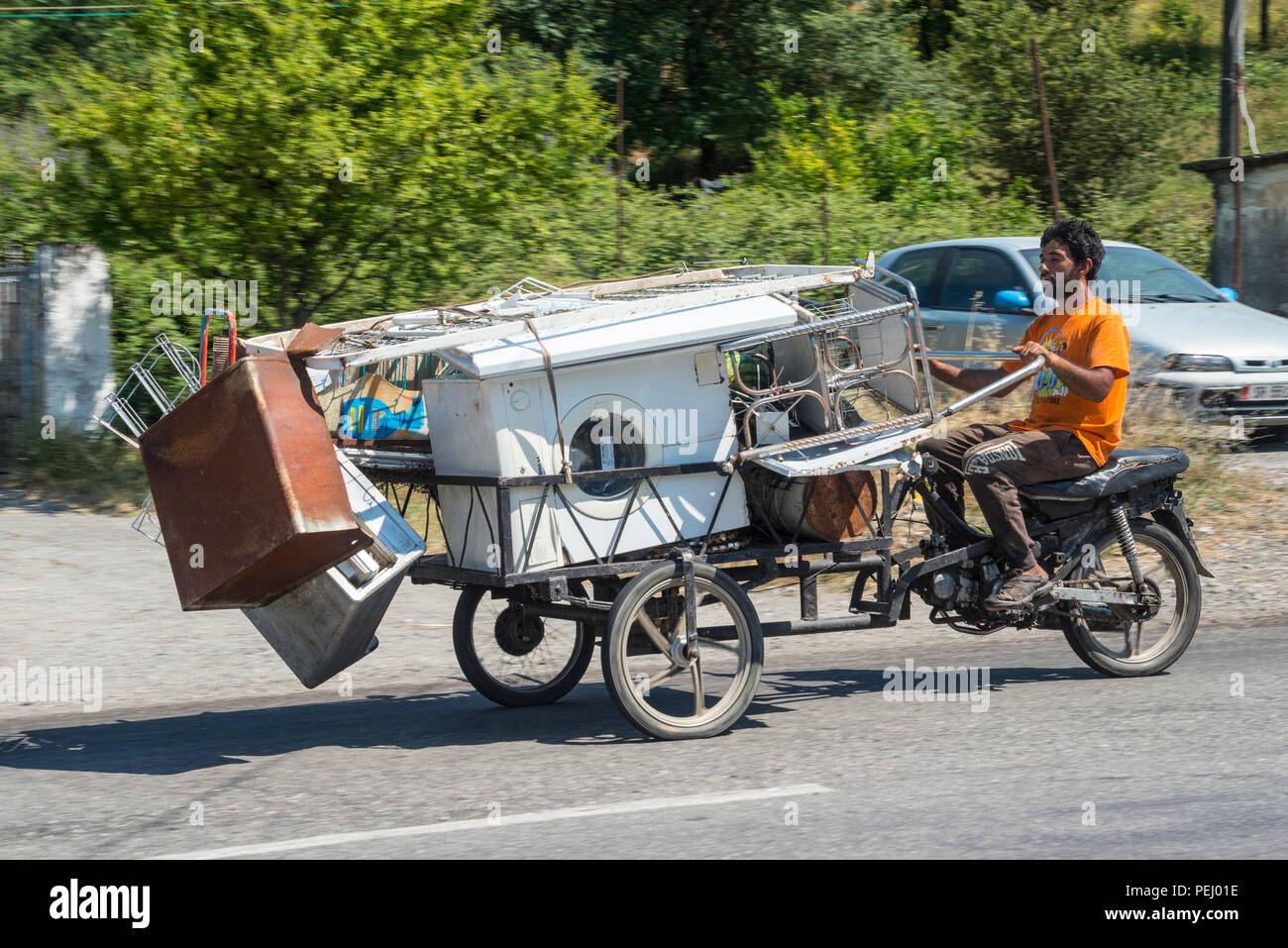 Collecteur de ferraille équitation un tricycle panier converti d'un cyclomoteur, près de Shkodra, le nord de l'Albanie. Banque D'Images