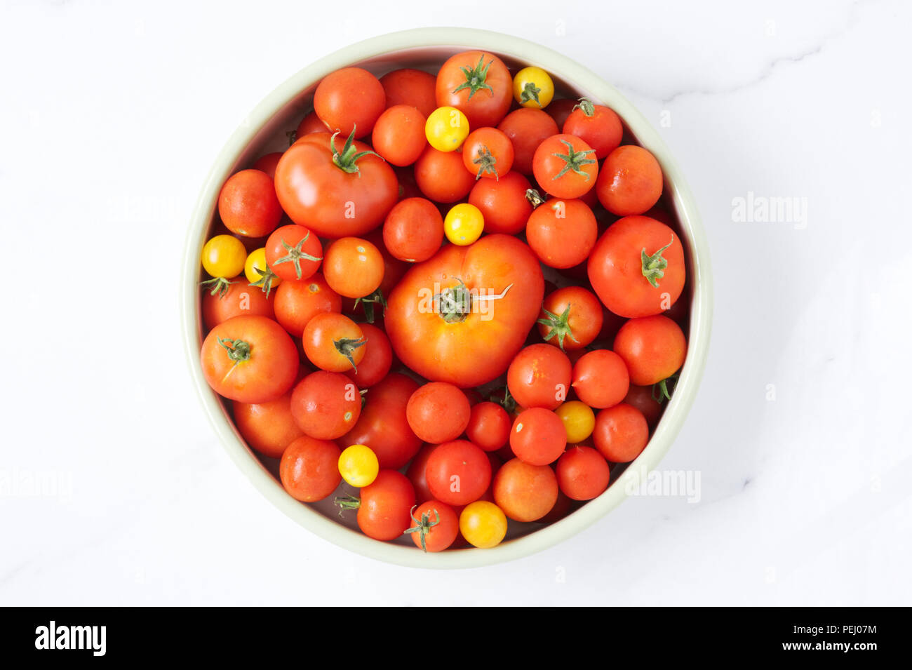 Lycopersicon esculentum. La récolte de tomates d'été sur un en arrière-plan. Variétés mixtes. Banque D'Images