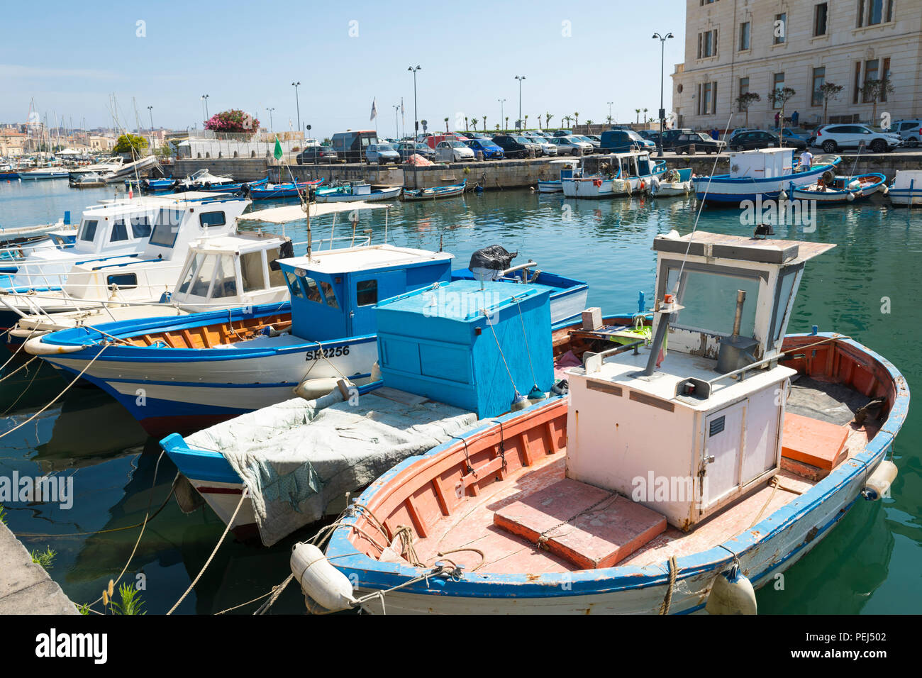 Italie Sicile Syracuse Ortigia Syracuse Porto Piccolo Petit Port de bateaux de pêche en eau peu profonde réflexion mer déchets débris quayside Banque D'Images