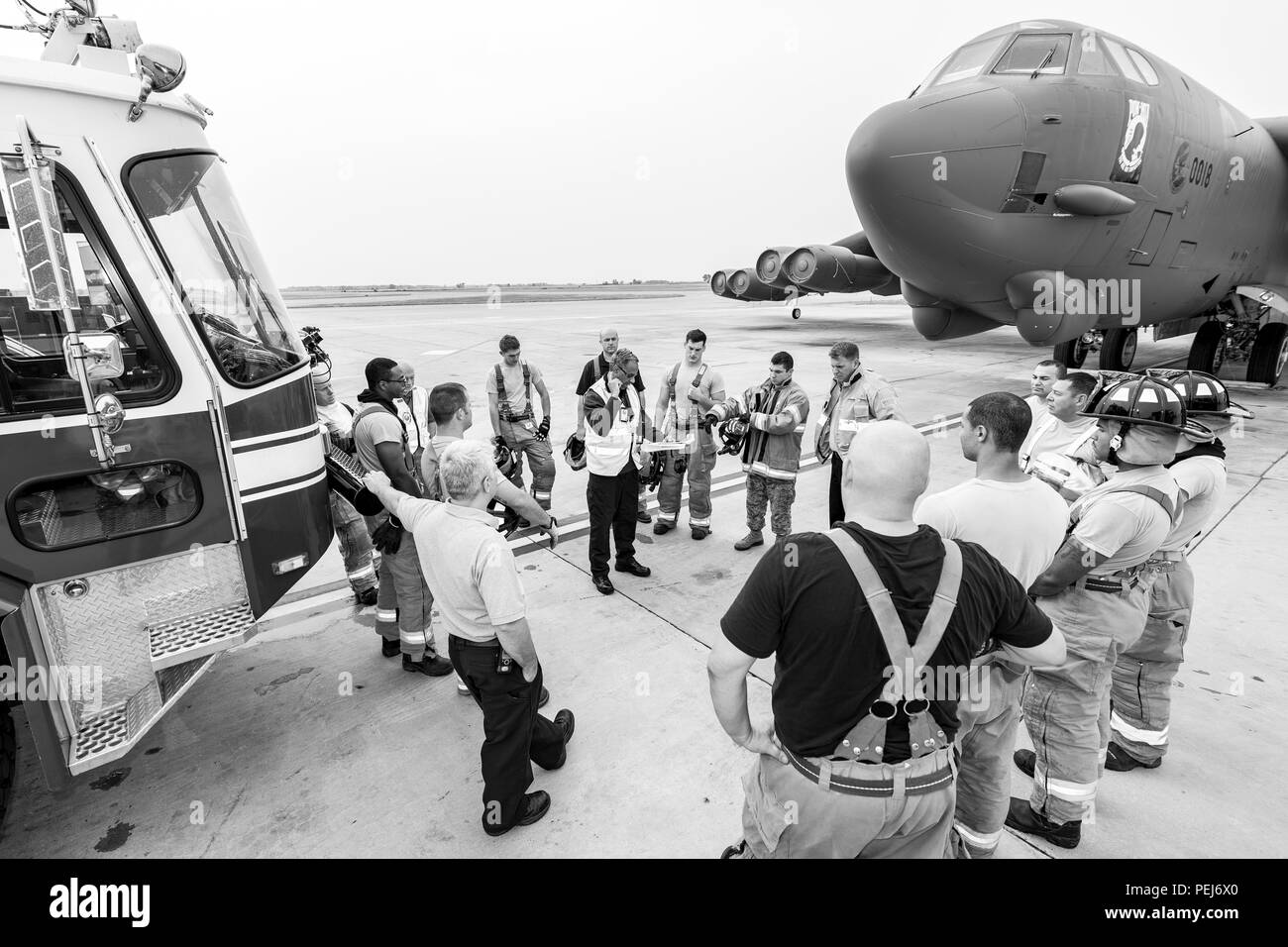 Charles Shipley, Inspecteur général Inspecteur de Base aérienne de Barksdale, réunit le personnel du 5e Escadron de génie civil sur la piste entre un camion et un B-52H Stratofortress pour discuter de leur entraînement physique à Minot Air Force Base, N.D., le 28 août 2015. L'exercice a duré environ une heure et vérifié la capacité de 15 membres de la 5e ces pompiers pour travailler en équipe. (U.S. Air Force photo/ Navigant de première classe J. T. Armstrong) Banque D'Images