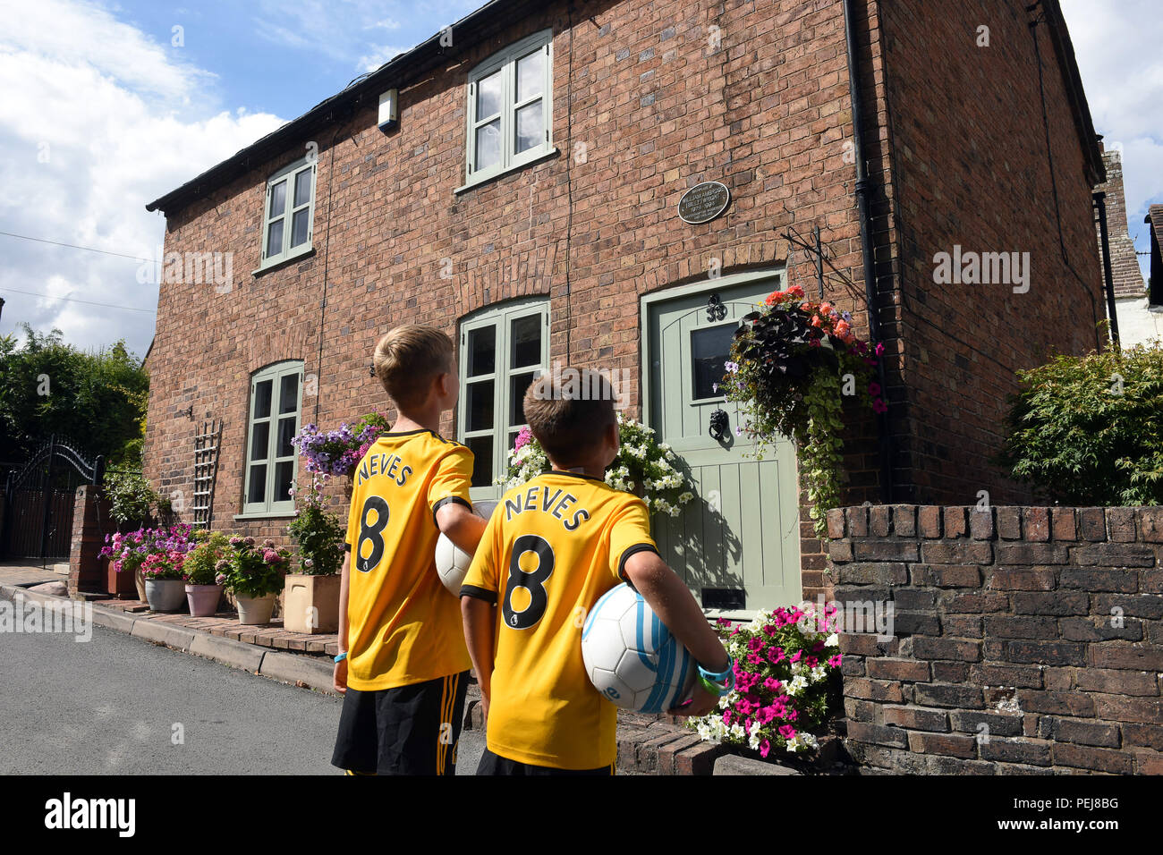 Les garçons à Wolverhampton Wanderers FC kits réplique à jouer au football à l'extérieur de la maison natale de loups et Angleterre légende footballistique Billy Wright dans Ironb Banque D'Images