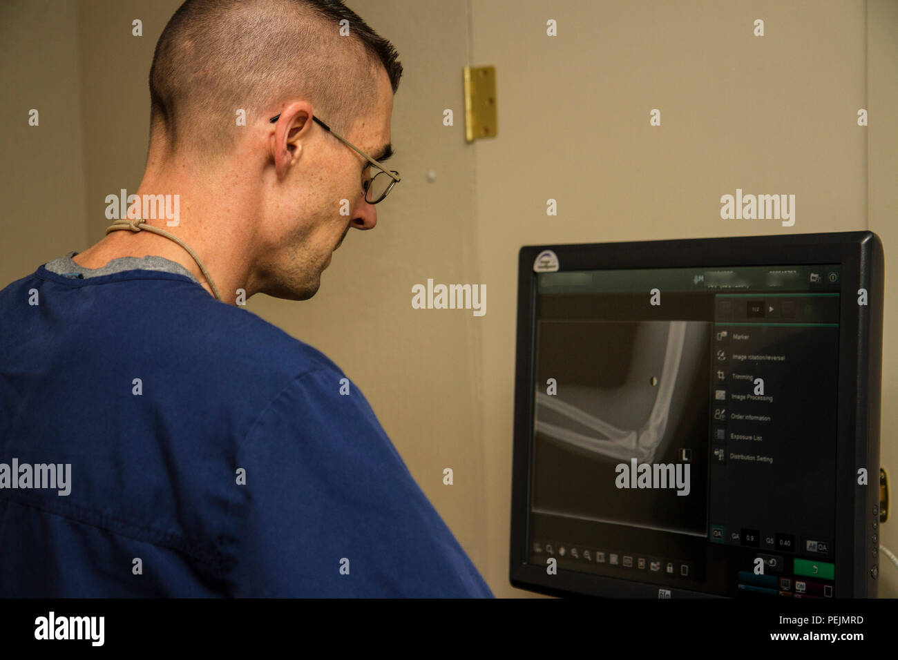 2015 Réserve de l'Armée de percer le sergent de l'année, le s.. Mark Mercer, 95e Division de la formation (IET), examine une radiographie du coude d'un patient à une clinique orthopédique à Edmond, en Oklahoma, le 7 décembre 2015. Mercer a commencé sa carrière dans l'armée de réserve comme X-ray technician et obtenu sa certification civile reconnu à l'échelle nationale en tant que technicien en radiologie par sa formation avec l'armée dans la formation individuelle avancée à Fort Sam Houston le Joint Base San Antonio. (U.S. Photo de l'armée par le Sgt. 1re classe Brian Hamilton) Banque D'Images