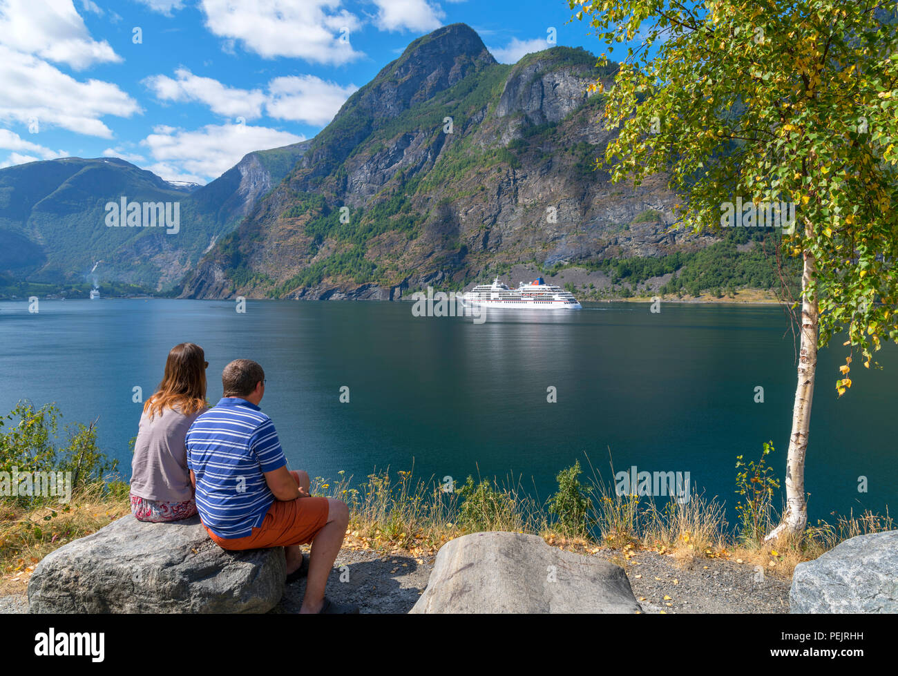 Couple regardant un bateau de croisière naviguant dans l'Aurlandsfjord, Flåm, Sognefjord, Sogn og Fjordane, Norvège Banque D'Images