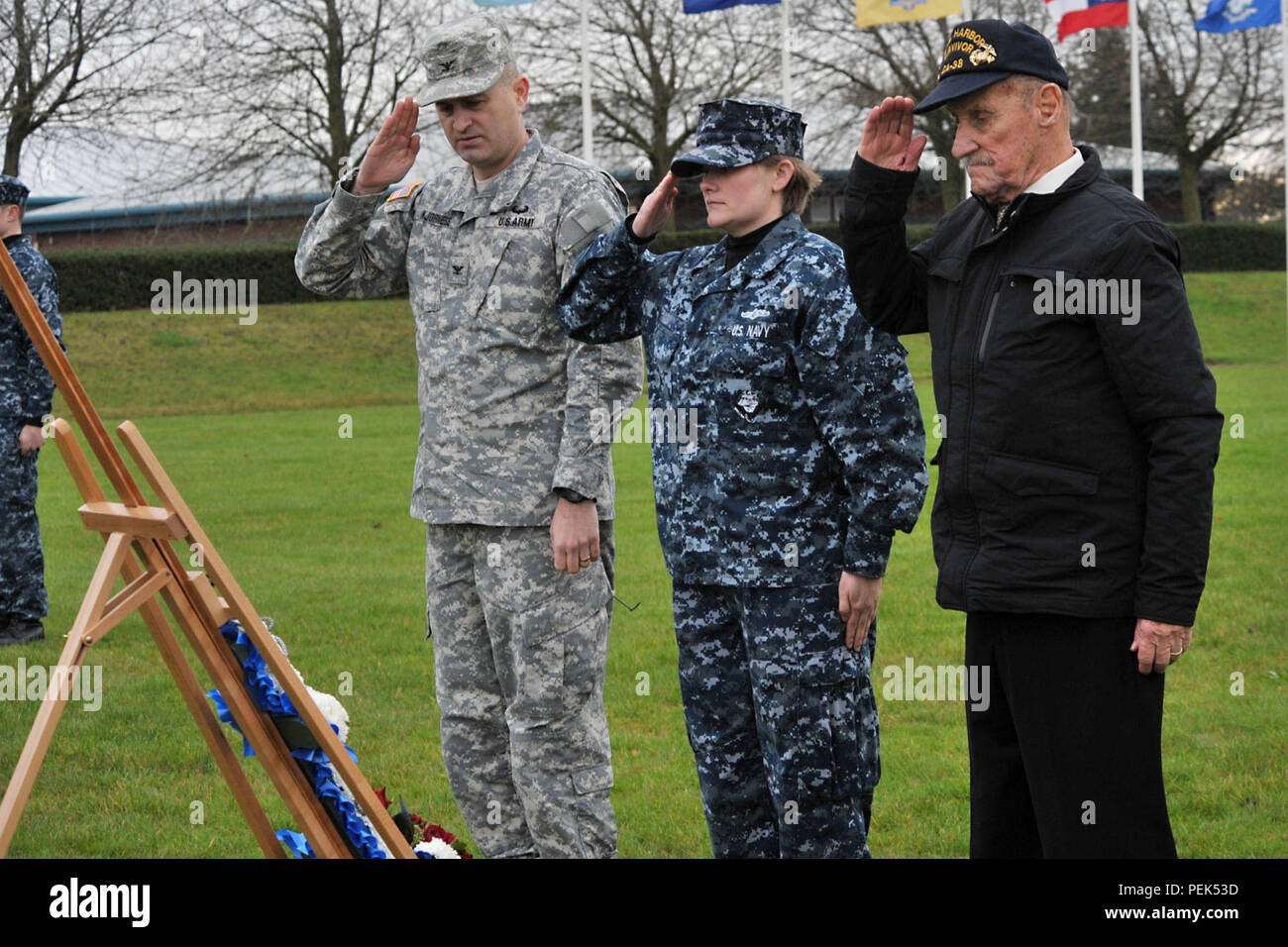 De gauche, de l'armée américaine le Colonel Mark Kjorness, U.S. Africa Command joint intelligence directeur, matelot de la Marine de Sydney, USAFRICOM, analyste de la division et survivant de Pearl Harbor, ancien Marine Sgt. John Egan, saluer une couronne après la mise à l'honneur des victimes de Pearl Harbor Pearl Harbor durant la 74e cérémonie de commémoration à RAF Molesworth, Royaume-Uni, 7 décembre 2015. En plus du dépôt de gerbes, la cérémonie comprenait le jeu de tarauds, un trois-volley saluer par la garde d'honneur et 423rd un survol aérien effectué par la 48e Escadre de chasse F-15 Eagle pilotes. (U.S. Photo de l'Armée de l'air par le sergent. Ashl Banque D'Images