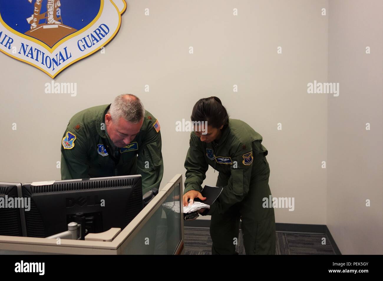 L'Illinois Air National Guard's Major Luc Varner, gauche, travaille avec les opérations offensives simulé U.S. Air Force Le Major Monika Johncour, droite, à partir de l'air et de l'Espace 612e au centre des opérations, la base aérienne Davis-Monthan Air Force Base, en Arizona, au cours de l'effort du pavillon virtuel, décembre 2-10, 2015, à Springfield, Illinois, l'unité de Varone 183d Air Operations Group, a accueilli le centre des opérations d'air partie de cet important exercice de combat. U.S. Air Force, de l'armée, de la Marine et des scénarios de formation conjointes menées à l'unité. Plus de 350 personnes ont participé par le biais de link-up fourni par l'US Air Force's Dist Banque D'Images