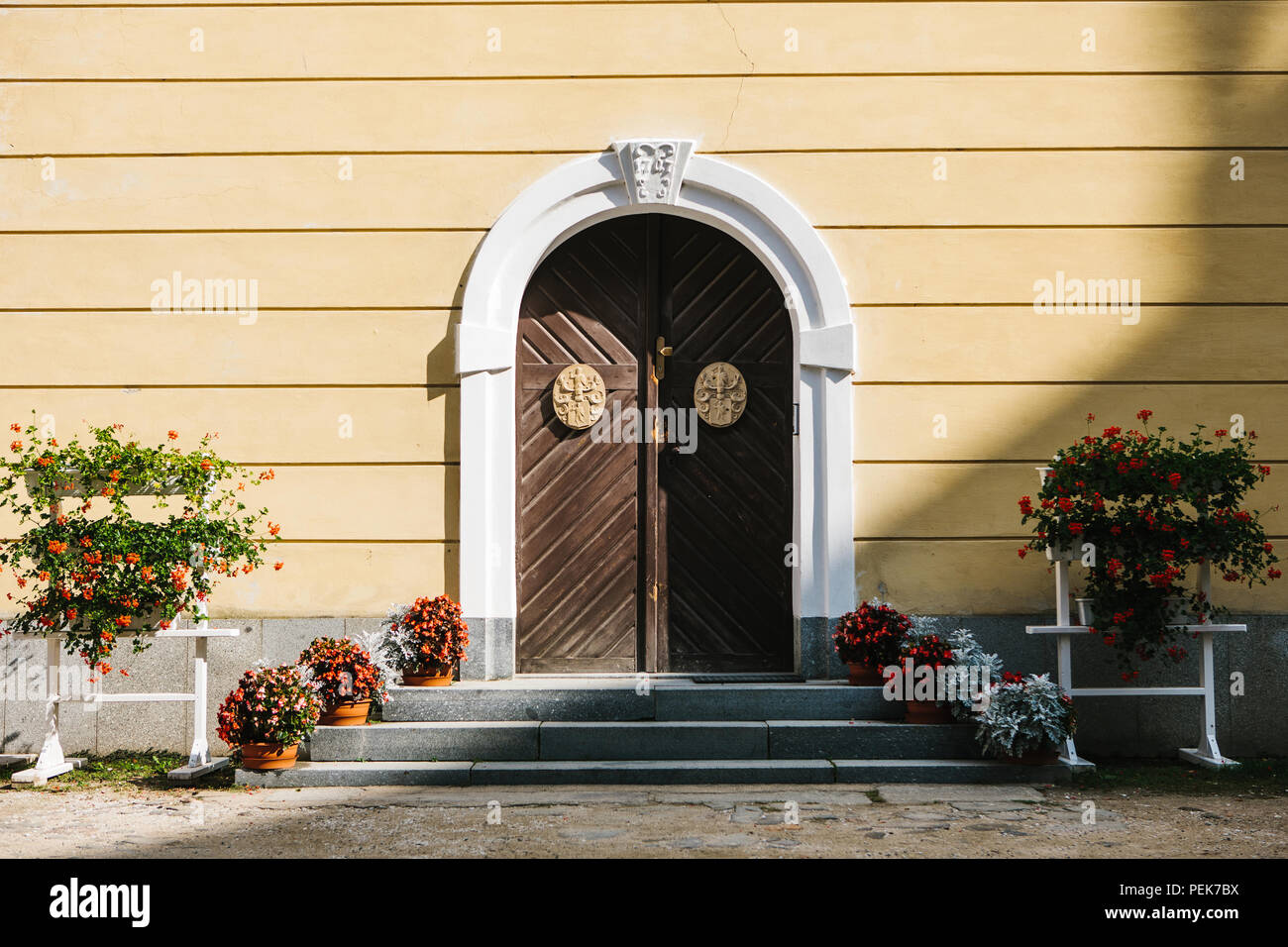 Belles portes cintrées avec éléments de décoration et de fleurs de chaude journée ensoleillée Banque D'Images