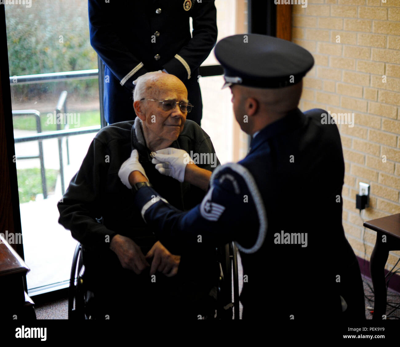 Roy Mullinax, un vétéran de l'Armée La Seconde Guerre mondiale, parle avec le TEC. Le Sgt. Terrance Williams, 22e Escadre de ravitaillement en vol sous-officier responsable de la garde d'honneur, au cours d'une cérémonie de reconnaissance, le 8 décembre 2015, à Newton, Kan. Mullinax enrôlé dans l'Armée de l'air peu après la fin de la Seconde Guerre mondiale, et ses années de service militaire a permis à sa reconnaissance avec la goupille dans son centre de soins palliatifs). (U.S. Air Force photo/Senior Airman Victor J. Caputo) Banque D'Images