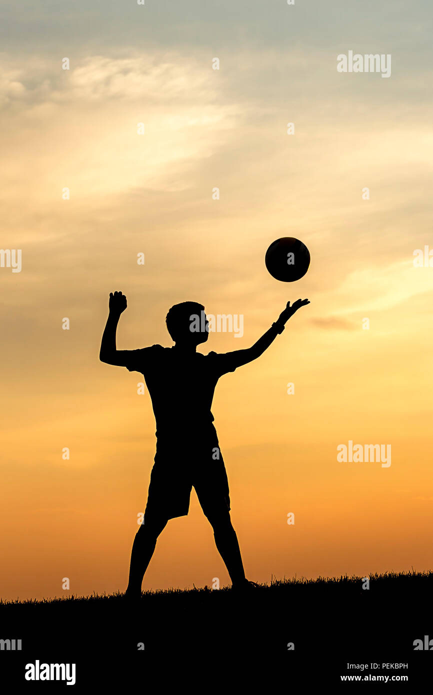 La silhouette du concept photo d'un jeune athlète s'reeady pour servir un terrain de volley-ball. Banque D'Images