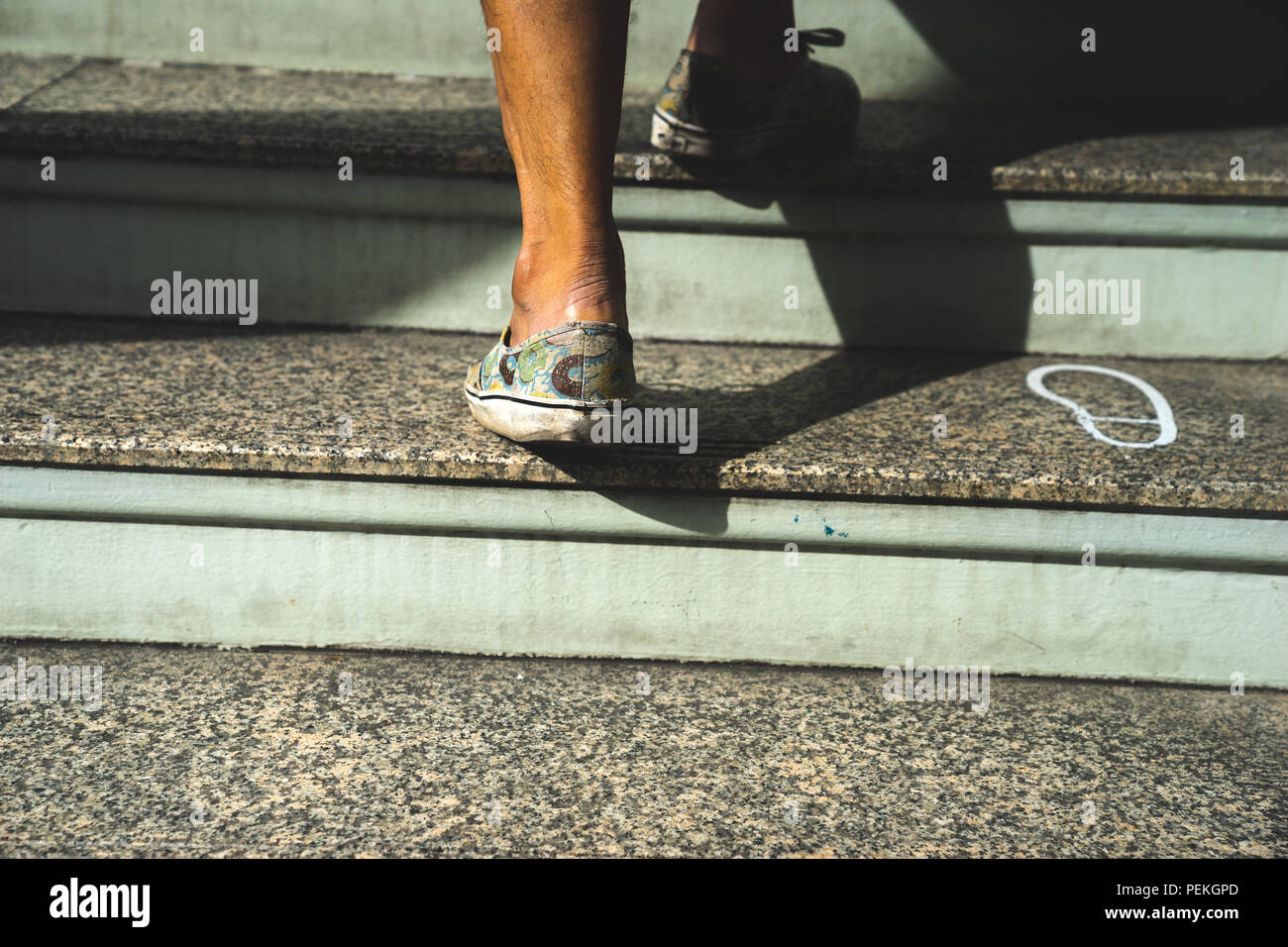 Close up shot jambe d'homme adulte en montant les escaliers Banque D'Images