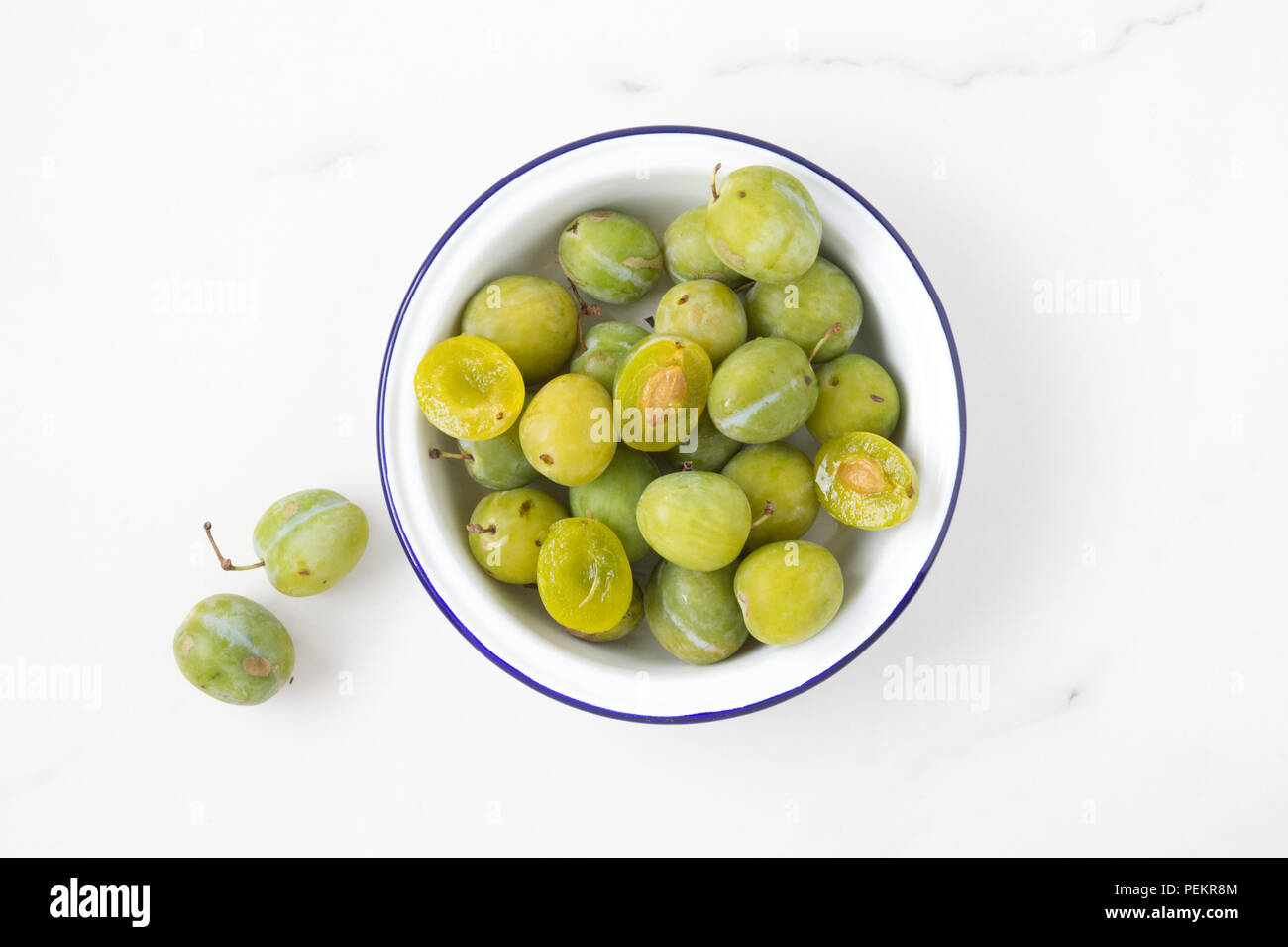 Prunus domestica Reine Claude. Greengages dans un bol. Banque D'Images
